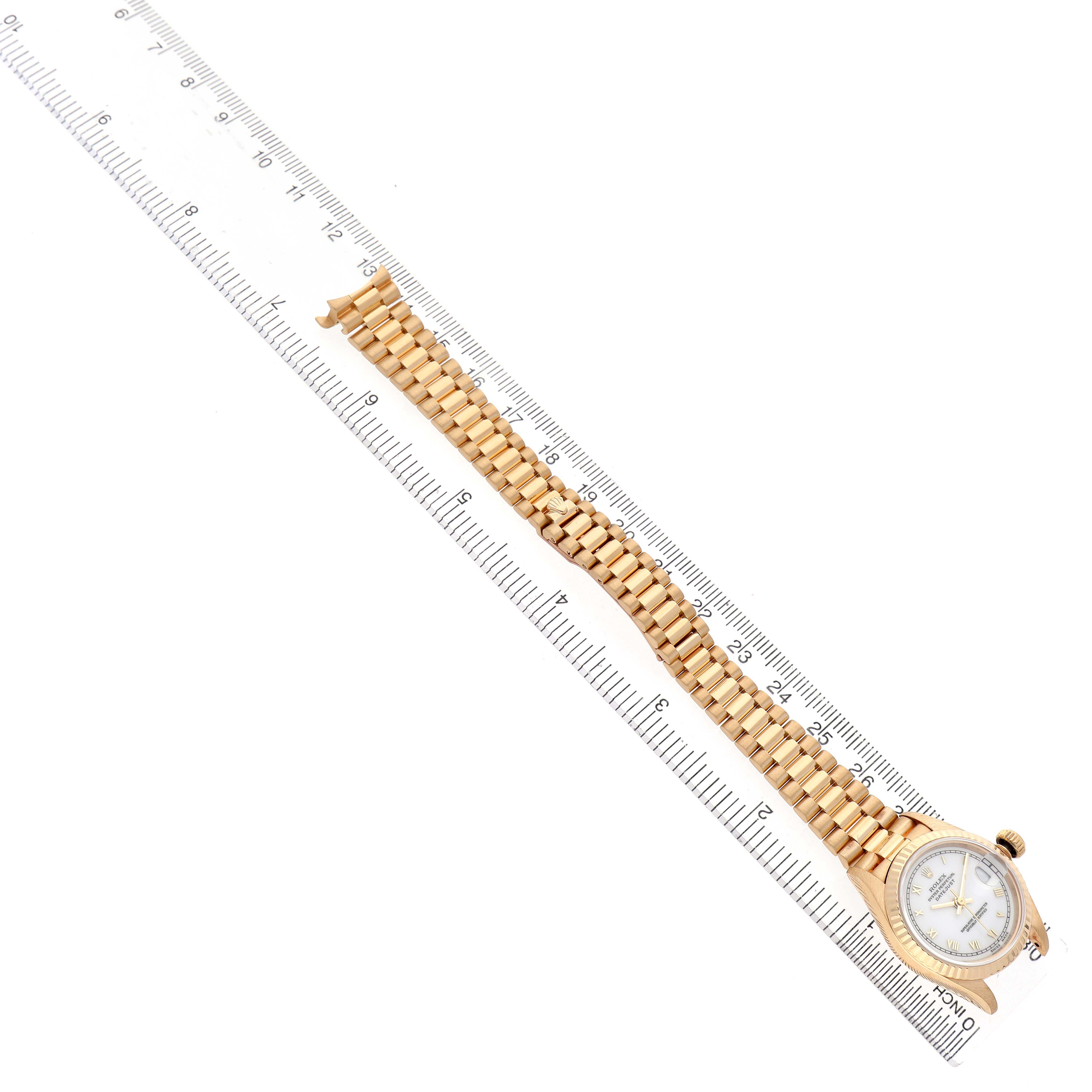 The Rolex President 69278 Women's Yellow Gold White Dial watch is displayed at an angle showing the full band and face, placed next to a ruler for size reference.