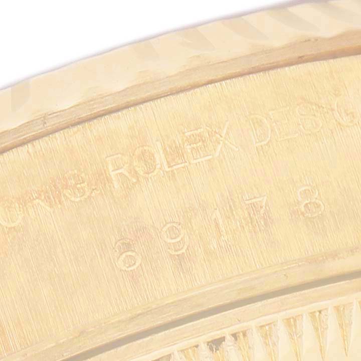 The image shows a close-up angle of the side of a Rolex President 69278 Women's Yellow Gold White Dial model, highlighting the engravings.