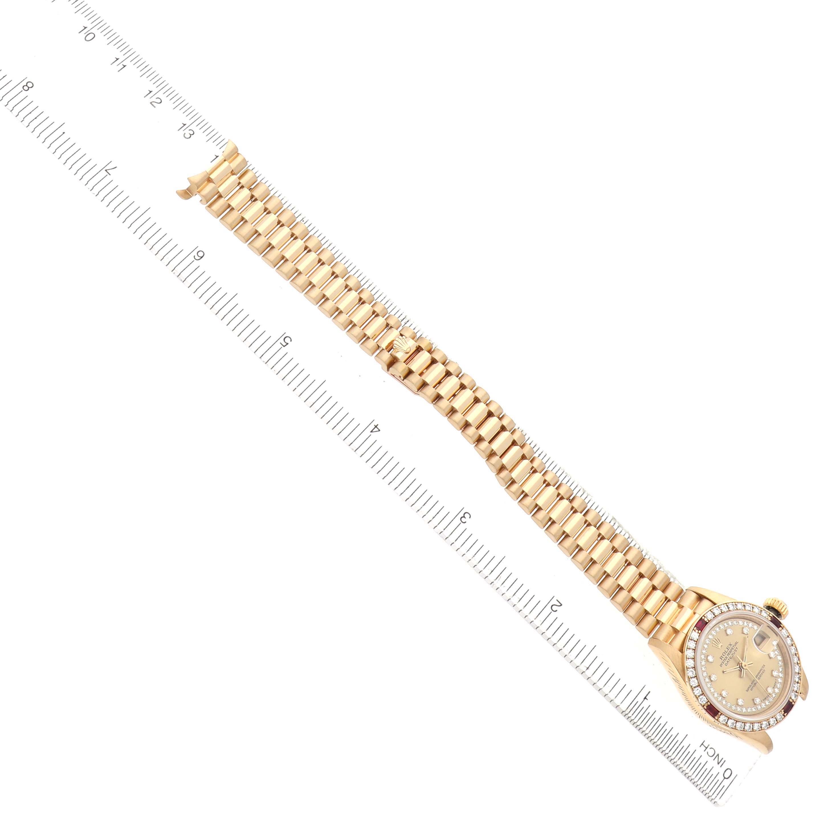 The Rolex President 69068 Women
s Yellow Gold Champagne Dial watch is shown from a top-down angle, highlighting the face and the full length of the bracelet against a ruler.