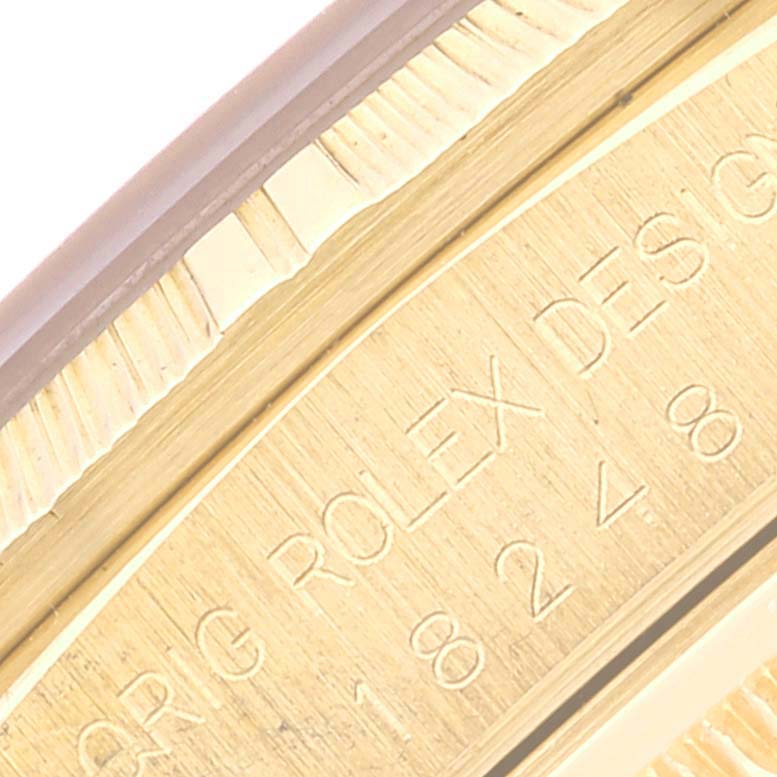 This is a close-up image of the inner bezel of a Rolex President 18248 Men's Yellow Gold Champagne Dial 18248 Men's Yellow Gold Champagne Dial model, showing the engraved text and part of the fluted outer bezel.