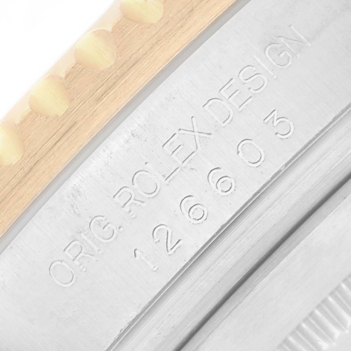 The image shows a close-up of the Rolex Sea-Dweller 126603 Men
s Steel and Gold (two tone) Black Dial model
s side, highlighting its bezel and engraved model number.