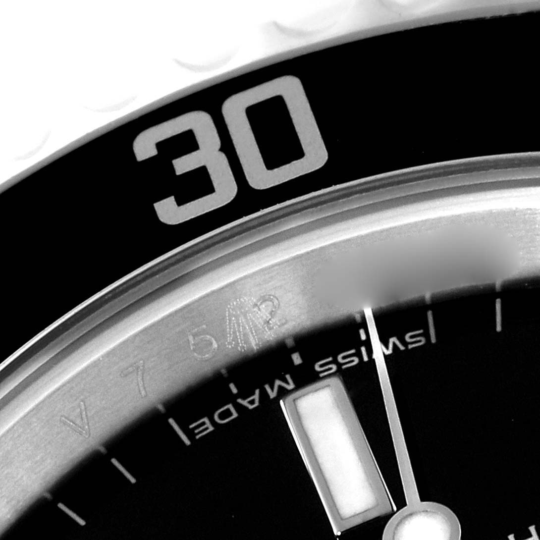 This close-up shows the bezel, a portion of the dial, and part of the hour marker of the Rolex Submariner 14060M Men
s Stainless Steel Black Dial 14060M Men
s Stainless Steel Black Dial watch.