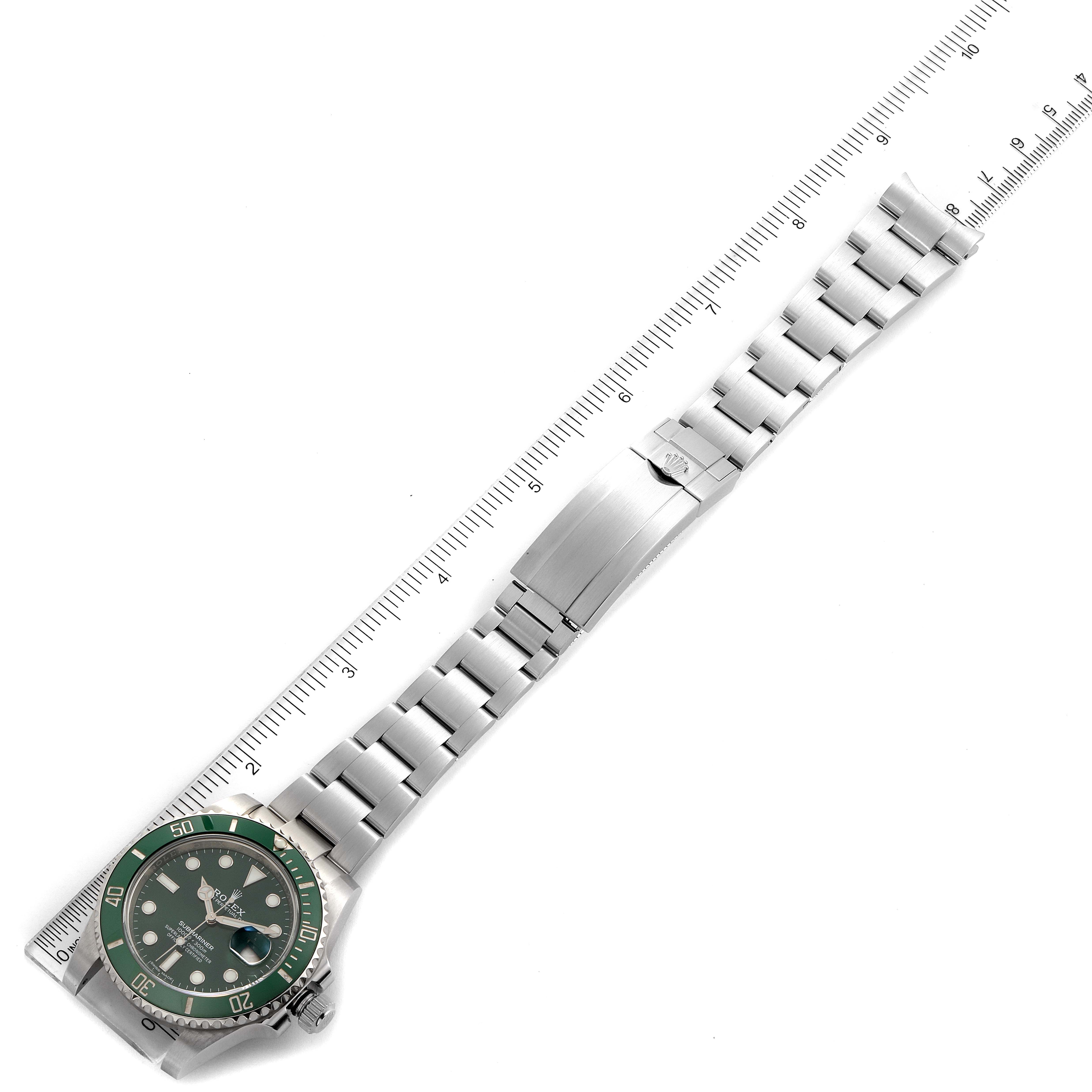 This image shows a top-down view of a Rolex Submariner 116610LV Men
s Stainless Steel Green Dial 116610LV Men
s Stainless Steel Green Dial watch displaying its face, bezel, and bracelet next to a ruler for size reference.