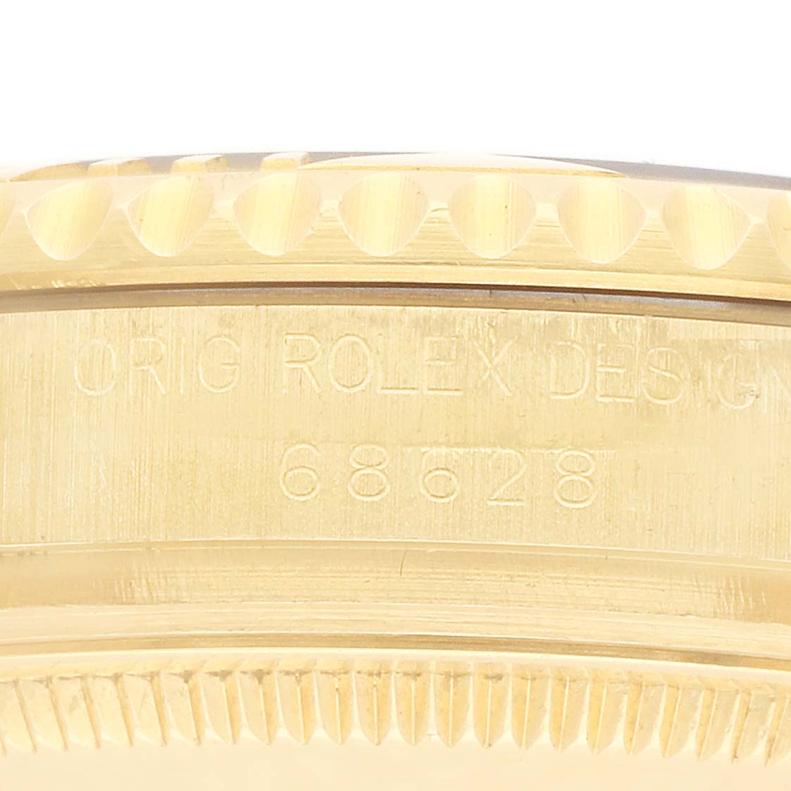 The image shows a close-up side view of the bezel and case of a Rolex Yacht-Master 68628 Men
s Yellow Gold White Dial, highlighting the engraving.