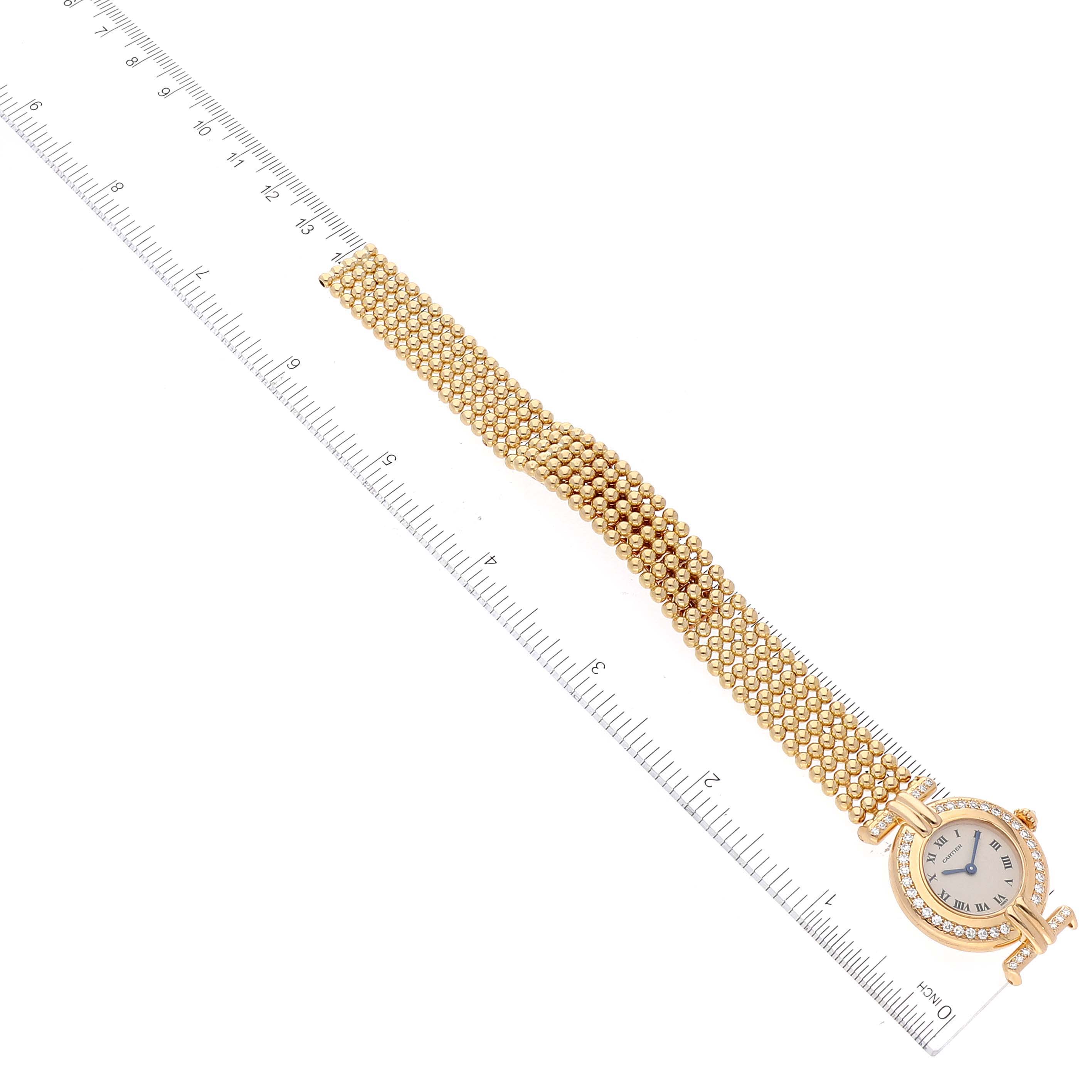 The image shows the Colisée model watch by Cartier from a top-down angle with the band positioned along a ruler.
