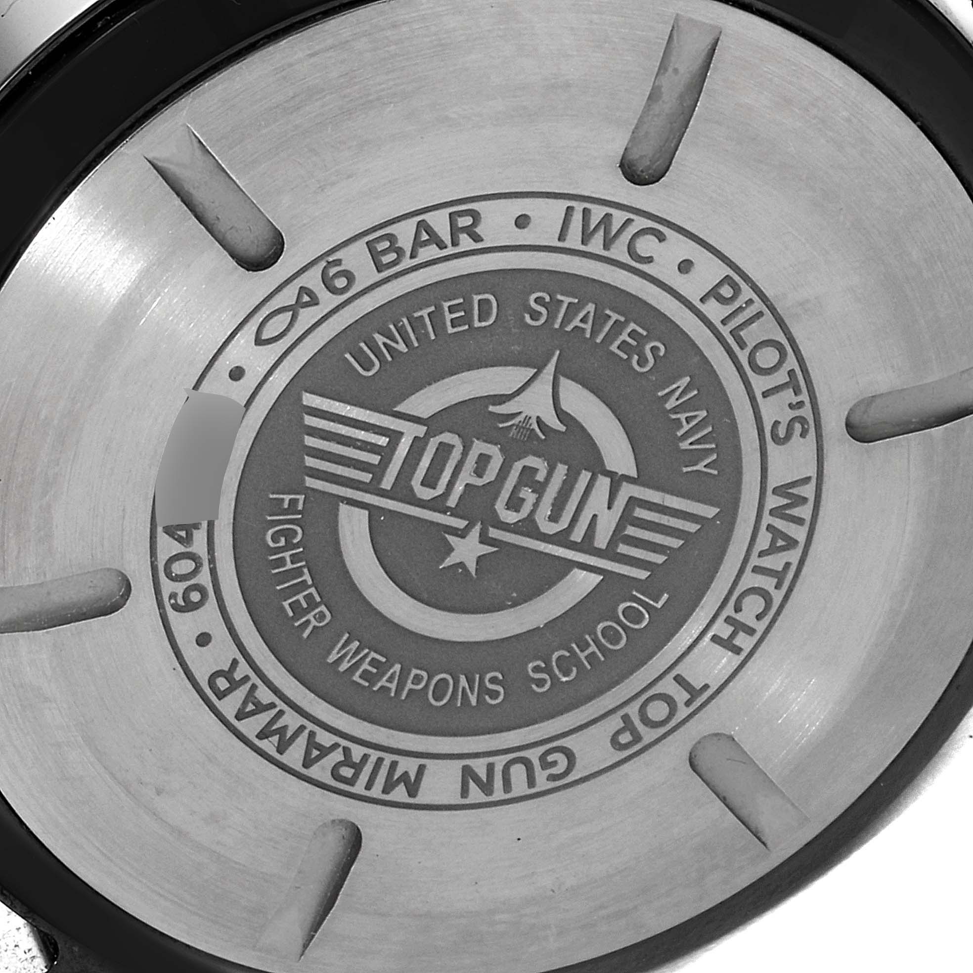 The image shows the case back of an IWC Pilot IW389002 Men's Ceramic Black Dial IW389002 Men's Ceramic Black Dial's Watch model, featuring "Top Gun" and "United States Navy Fighter Weapons School" engravings.