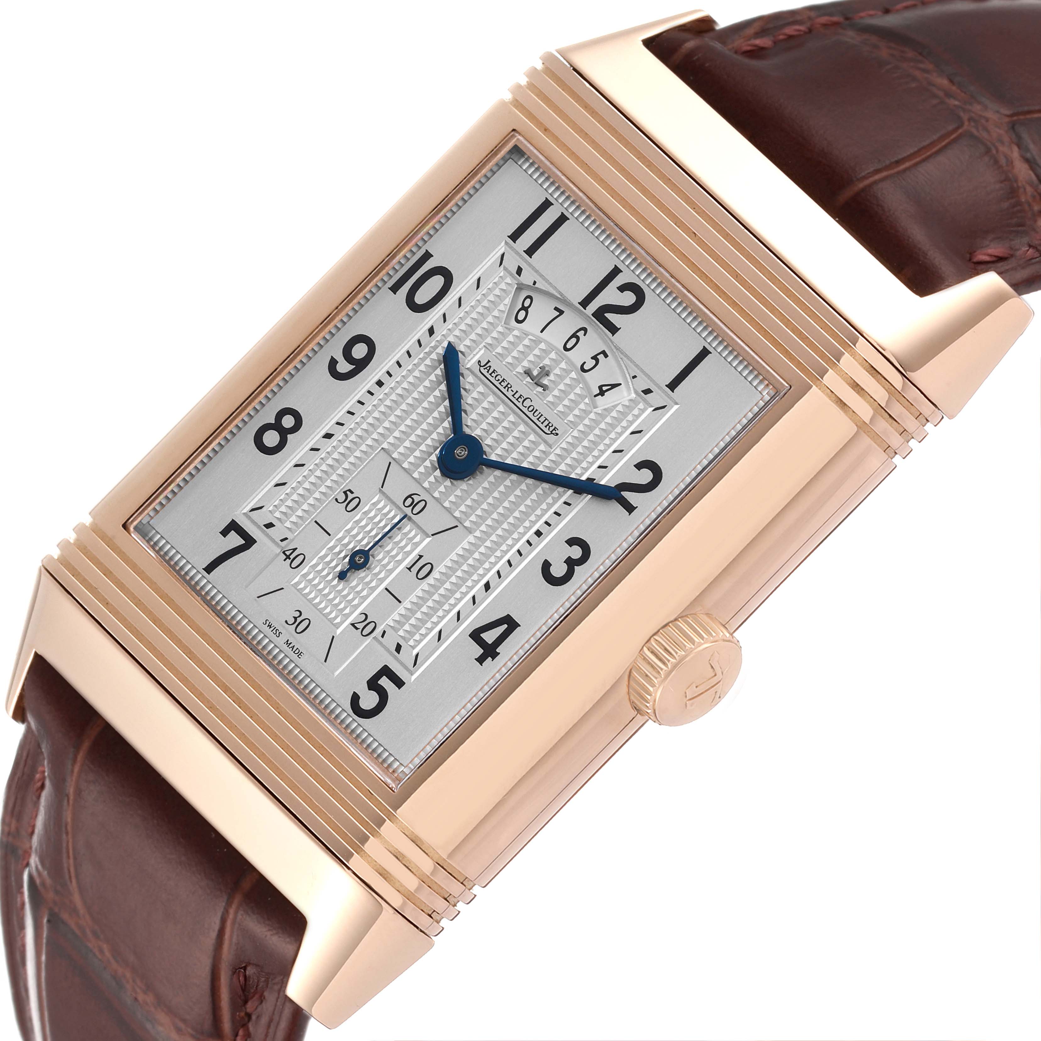 The image shows a close-up view of the Jaeger LeCoultre Reverso Q3742521 Men's Rose Gold Silver Dial Q3742521 Men's Rose Gold Silver Dial watch, highlighting the rectangular dial, crown, and leather strap.