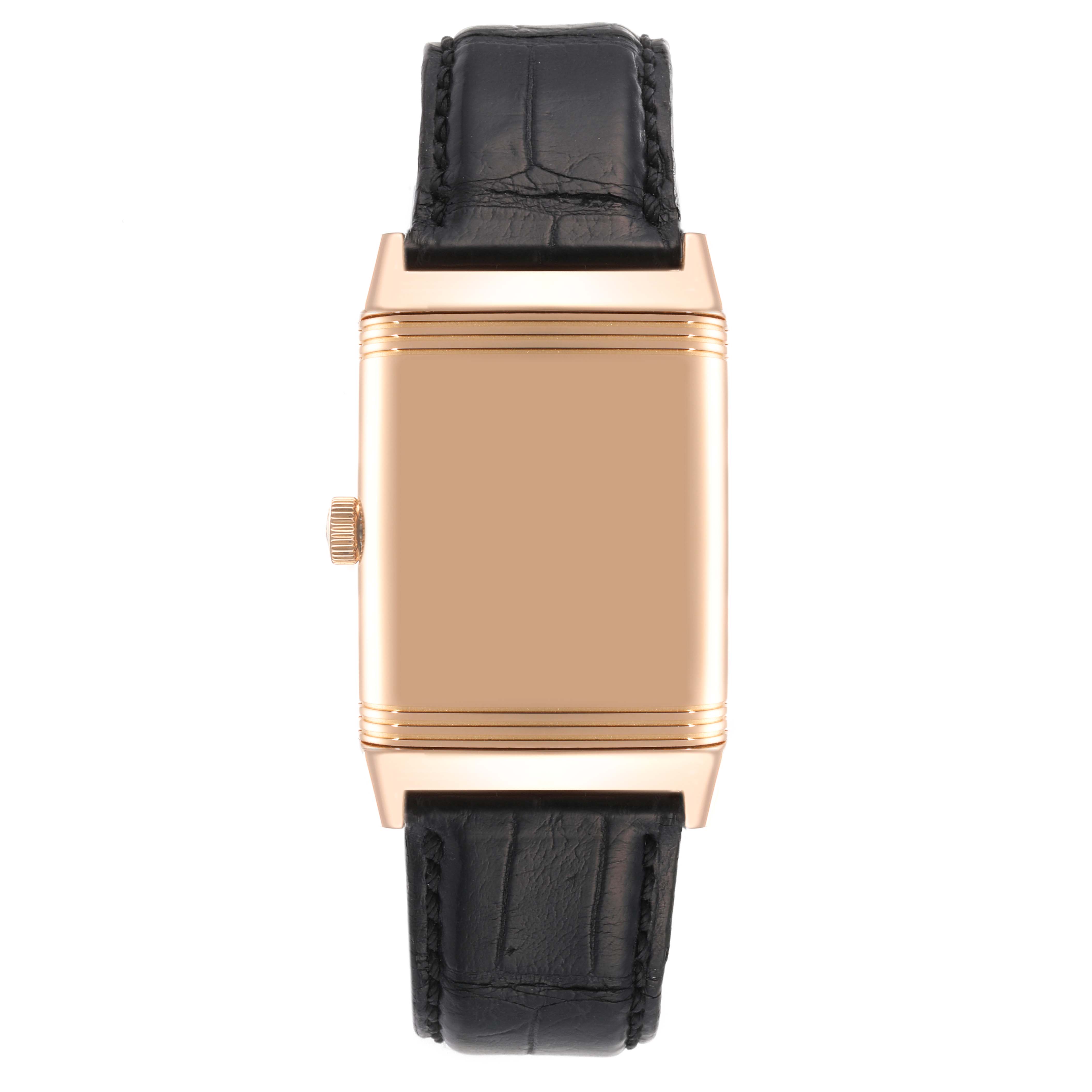 The image shows a close-up of the Jaeger-LeCoultre Reverso watch, highlighting its rectangular case back, crown, and leather strap from the front angle.