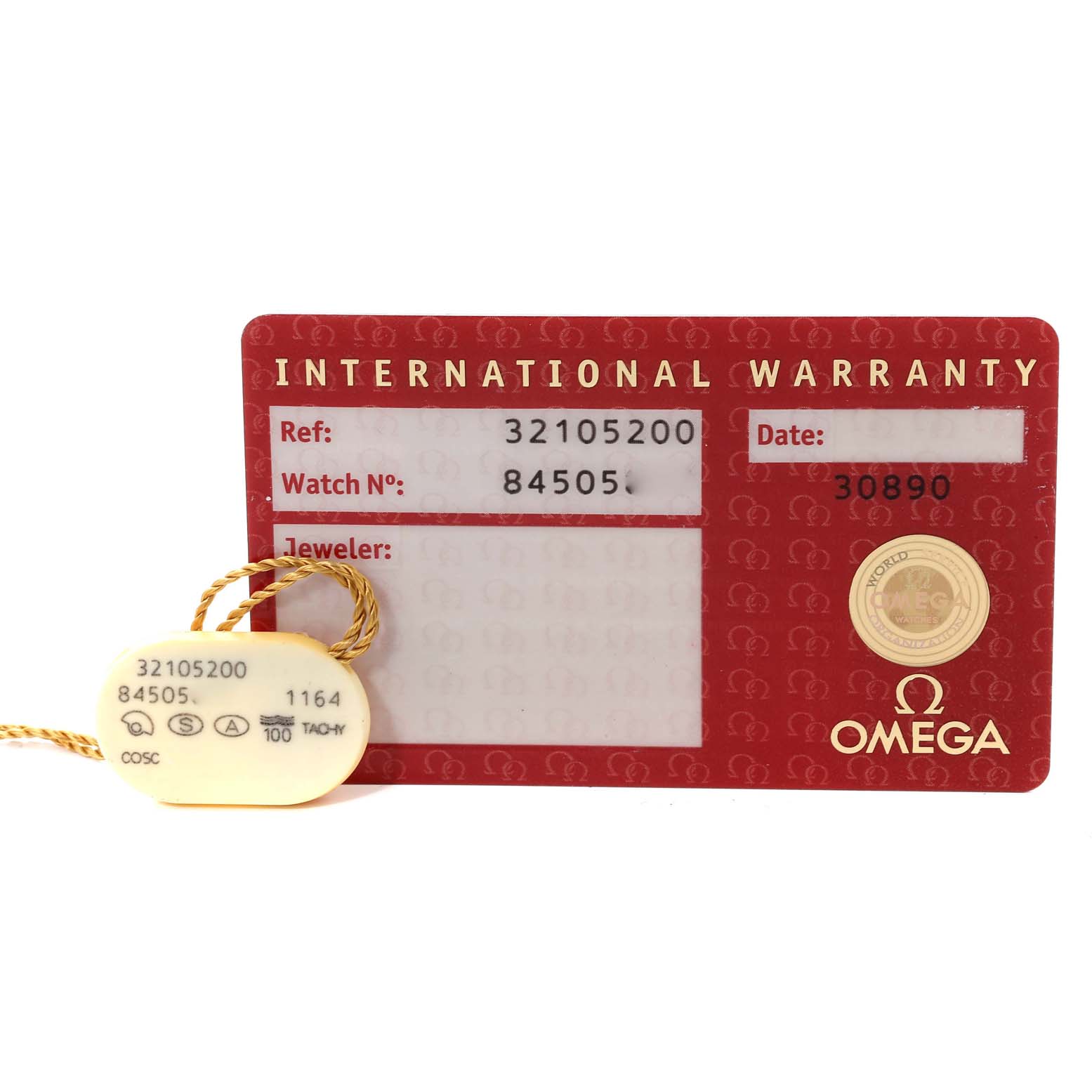 The image shows the international warranty card and tag for an Omega Speedmaster 3210.52.00 Men's Stainless Steel Black Dial 3210.52.00 Men's Stainless Steel Black Dial watch, viewed from a top angle.