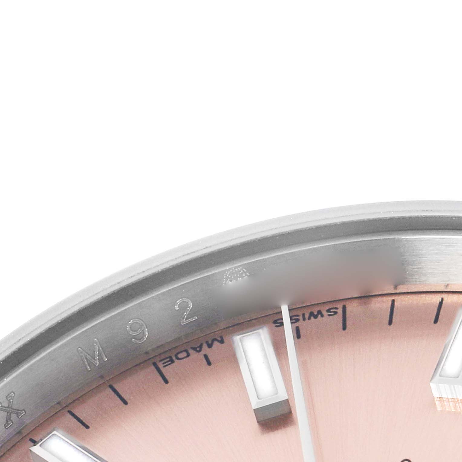 The image shows a close-up of the dial and bezel edge of a Rolex Date 115200 Men's Stainless Steel Pink Dial model, highlighting the markers and "Swiss Made" text.