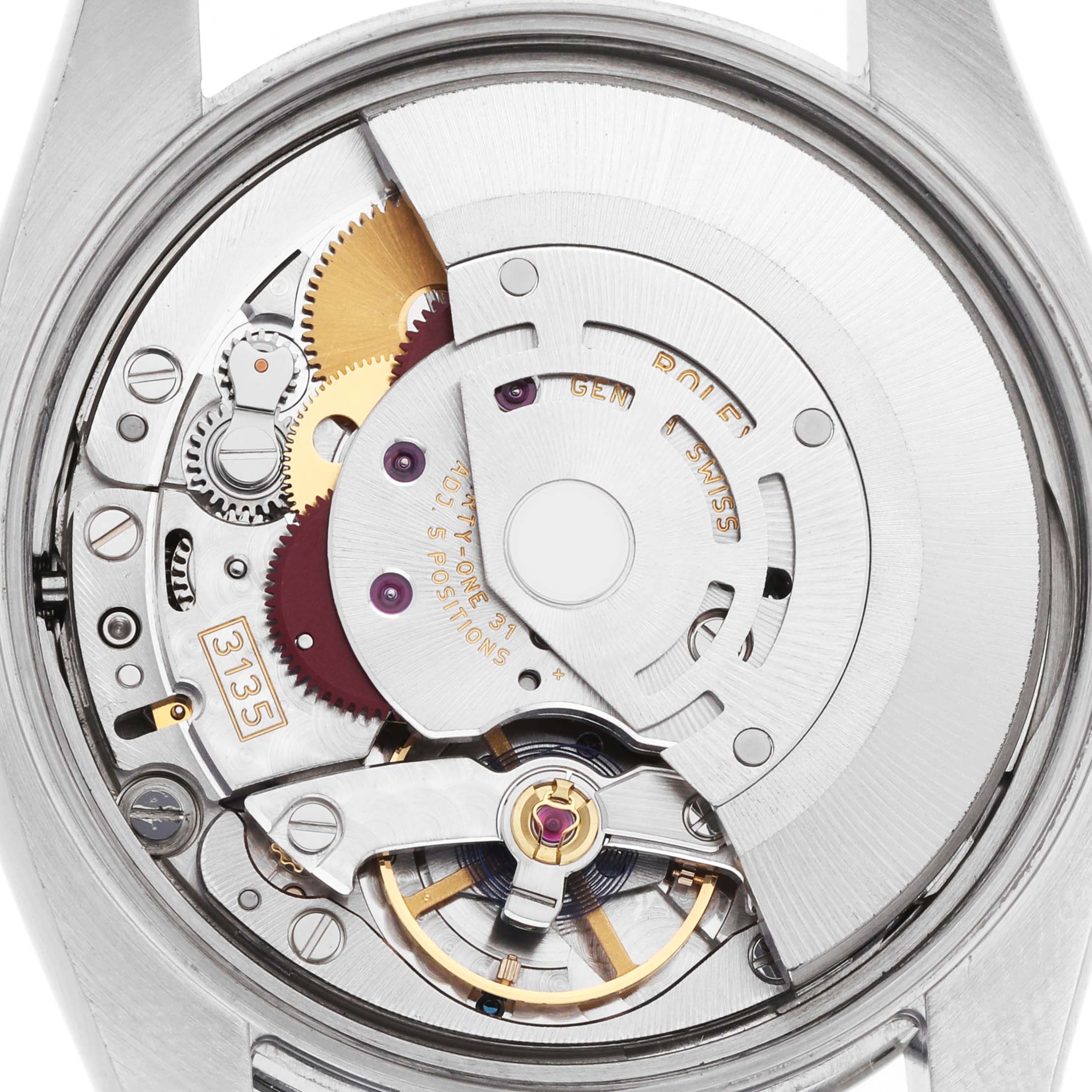 The image shows a close-up view of the movement inside a Rolex Date 115200 Men's Stainless Steel Pink Dial watch, highlighting gears and the rotor.