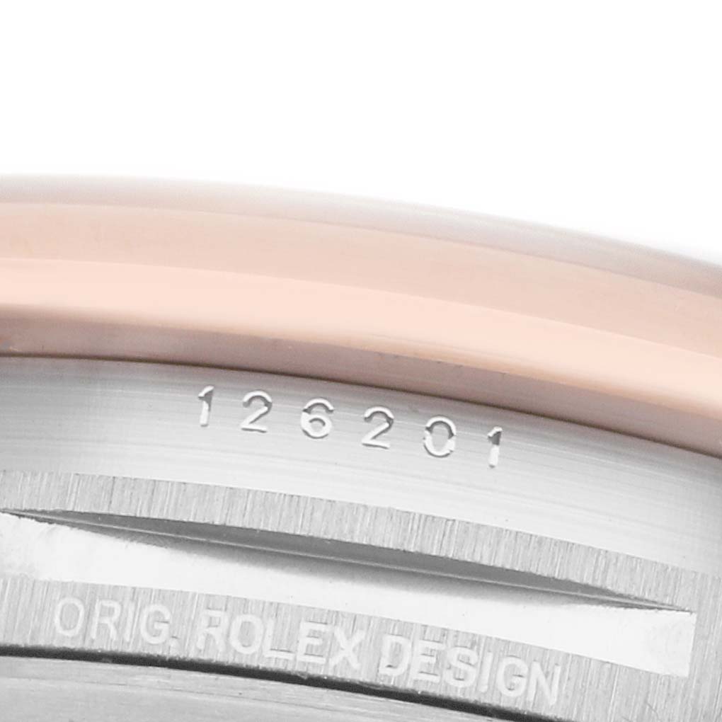 The image shows a close-up of the side of a Rolex Datejust 126201 Men's Steel and Gold (two tone) Grey Dial, highlighting the bezel and engraved serial numbers.