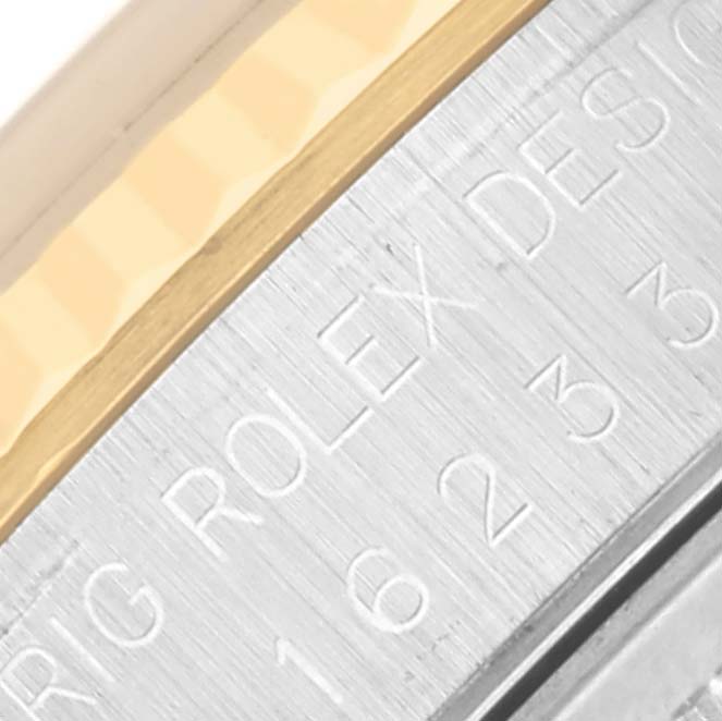 The image shows a close-up of the Rolex Datejust 16233 Men's Steel and Gold (two tone) Black Dial's bezel and engraved details on its side.