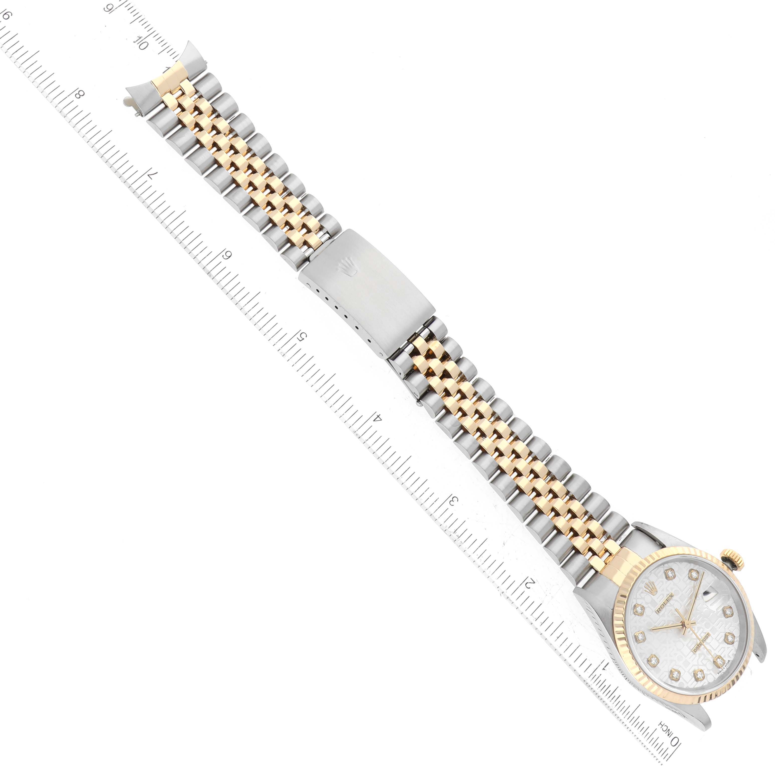 The image shows a Rolex Datejust 16233 Men
s Steel and Gold (two tone) Silver Dial 16233 Men
s Steel and Gold (two tone) Silver Dial watch laid flat, with the bracelet fully extended next to a ruler for scale.