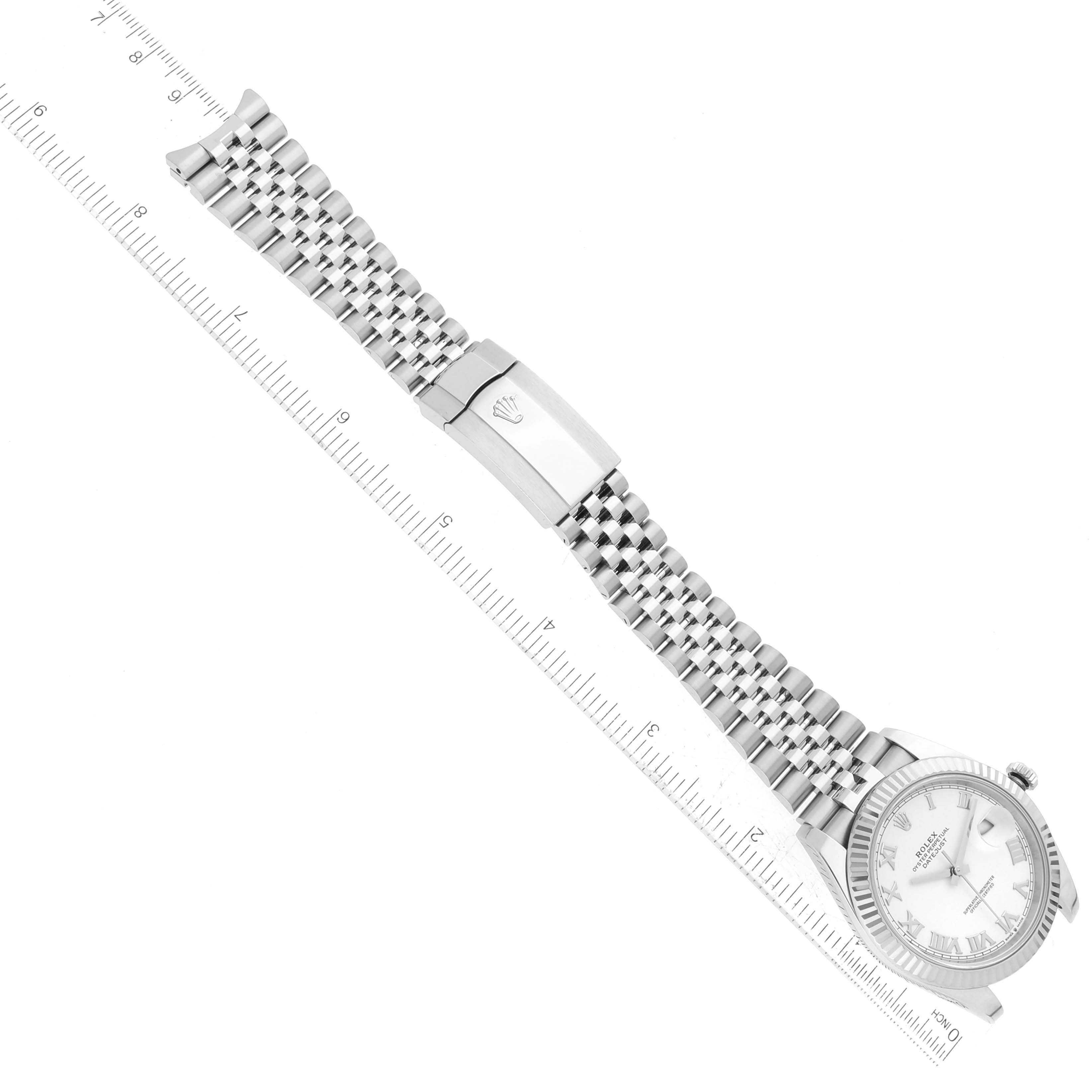 This image shows a Rolex Datejust 41 126334 Men's Stainless Steel White Dial 126334 Men's Stainless Steel White Dial watch laid flat next to a ruler, displaying its dial, bracelet, and clasp.