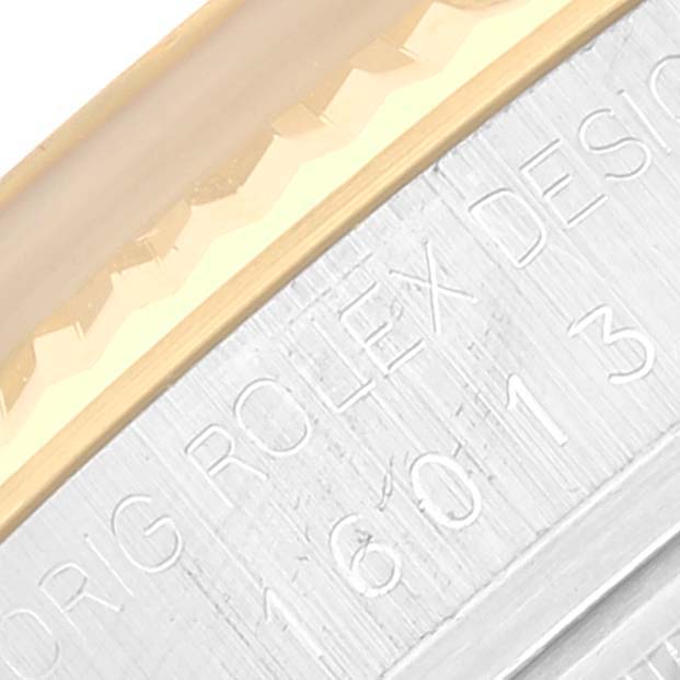 This close-up image shows part of the fluted bezel and engraved inner case of a Rolex Datejust 16013 Men's Steel and Gold (two tone) Champagne Dial 16013 Men's Steel and Gold (two tone) Champagne Dial.