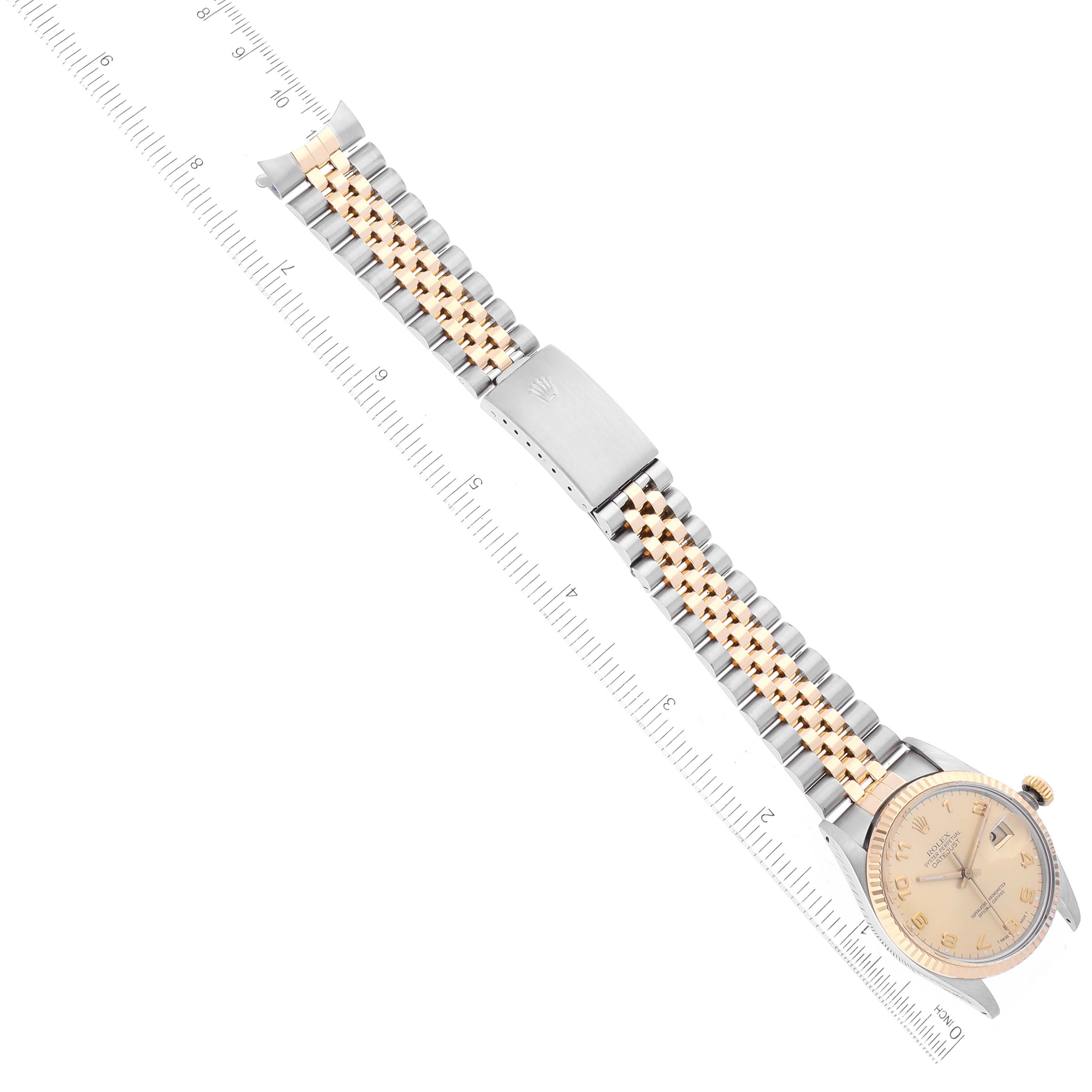 The image shows a top view of a Rolex Datejust 16013 Men's Steel and Gold (two tone) Champagne Dial 16013 Men's Steel and Gold (two tone) Champagne Dial watch, displaying its face, band, and clasp, measured alongside a ruler.