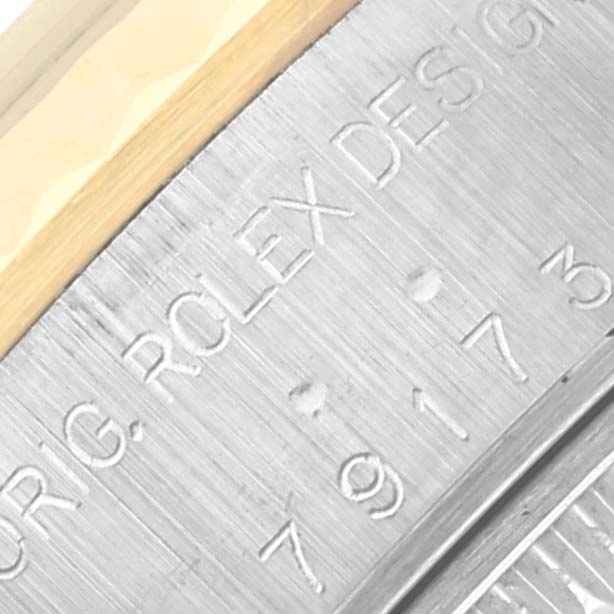 This image shows an angled, close-up view of the engraved inner bezel of a Rolex Datejust 79173 Women
s Steel and Gold (two tone) Mother of Pearl Dial 79173 Women
s Steel and Gold (two tone) Mother of Pearl Dial watch.