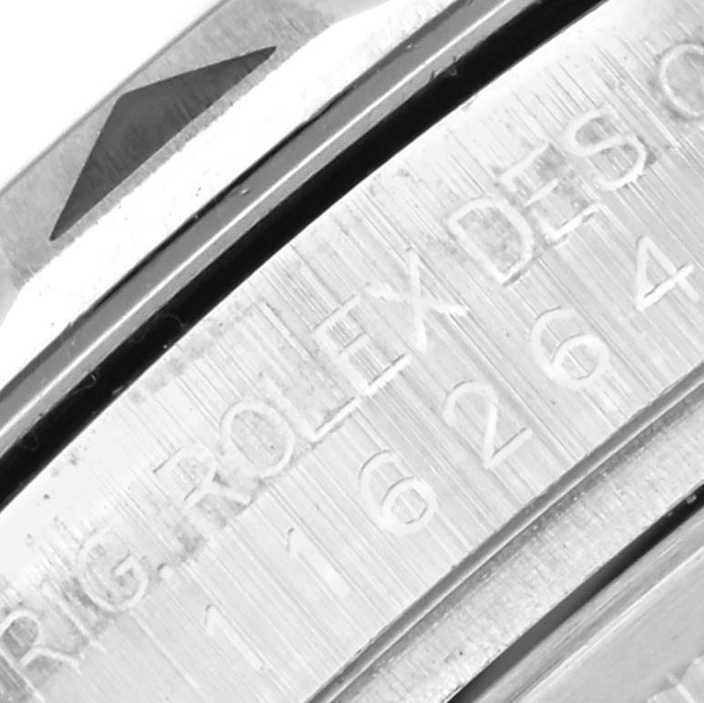 The image shows a close-up of the engraved bezel and part of the case of the Rolex Turn-o-Graph 116264 Men
s Stainless Steel Blue Dial 116264 Men
s Stainless Steel Blue Dial watch.