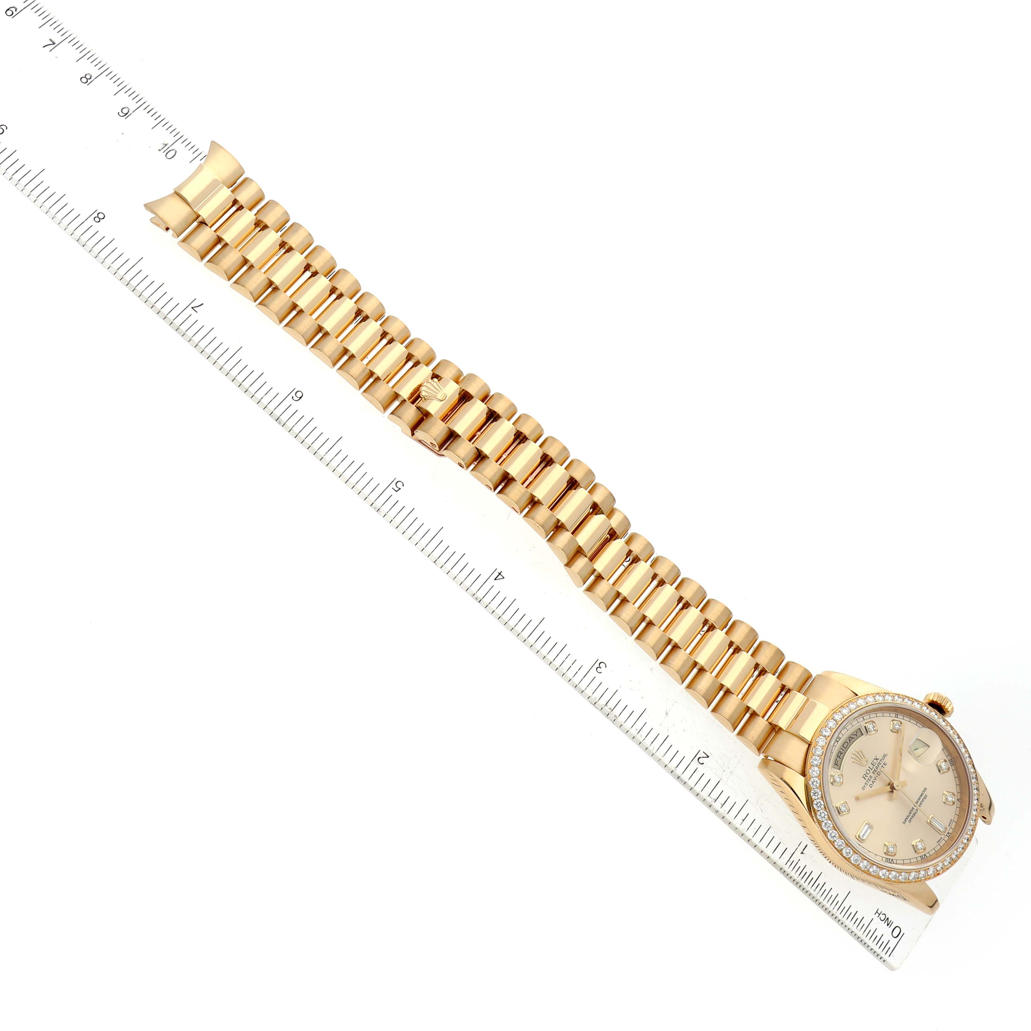 This image shows the Rolex President 118348 Men
s Yellow Gold Champagne Dial 118348 Men
s Yellow Gold Champagne Dial model watch laid flat with its band and dial visible, aligned next to a ruler.