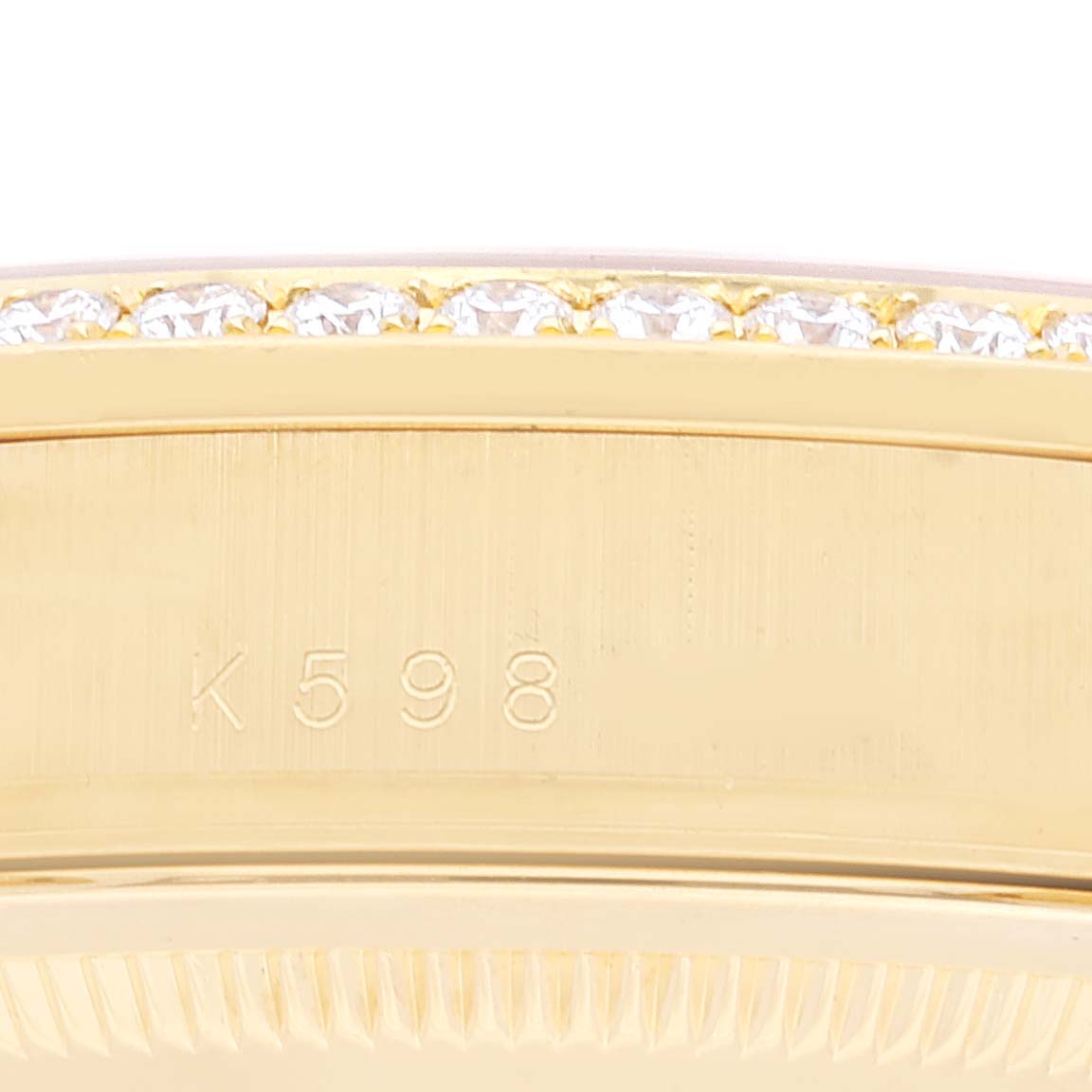 This image shows a close-up of the case and diamond-set bezel with an engraved number of a Rolex President 118388 Men's Yellow Gold Champagne Dial 118388 Men's Yellow Gold Champagne Dial model watch.