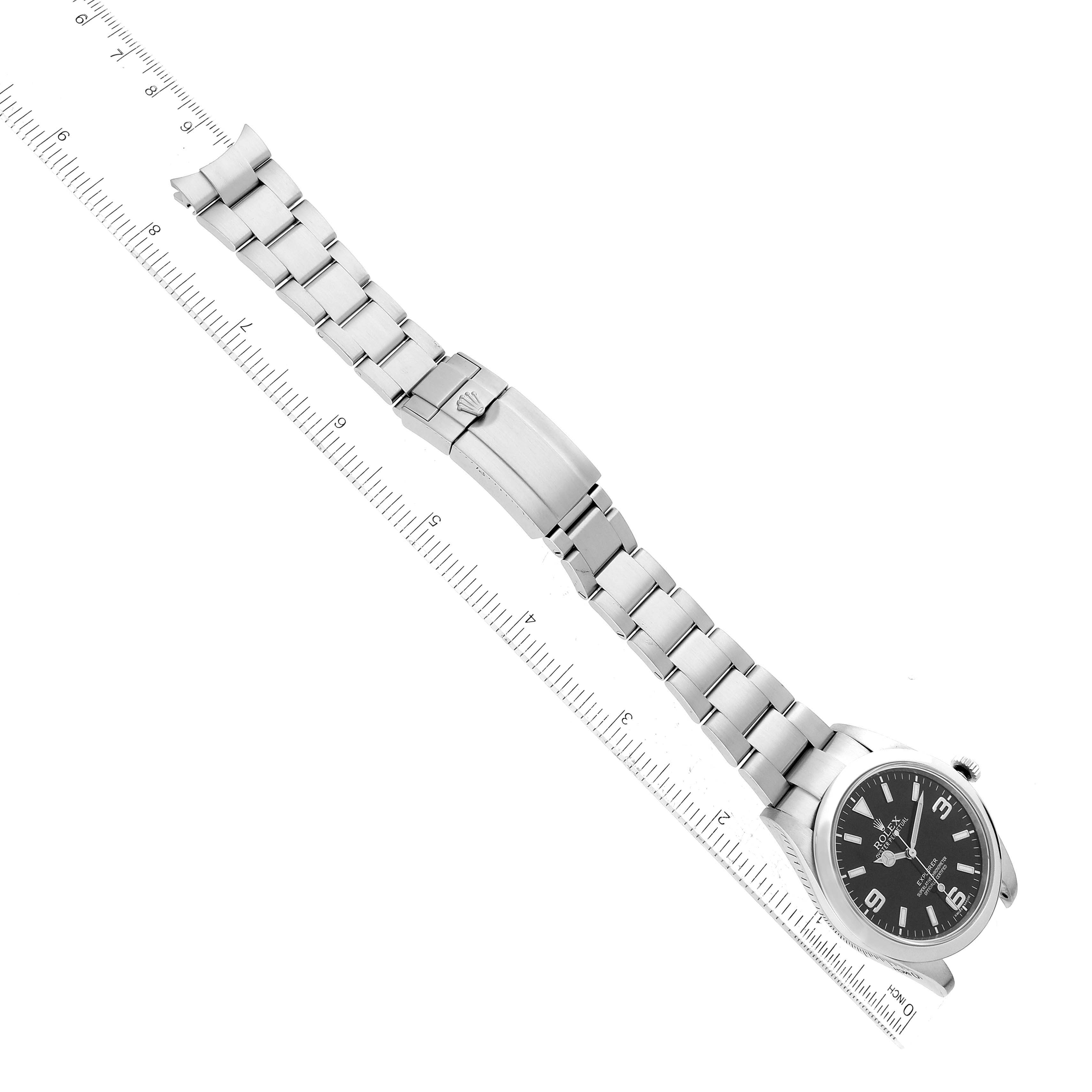 This image shows a Rolex Explorer 214270 Men
s Stainless Steel Black Dial 214270 Men
s Stainless Steel Black Dial watch laid flat, displaying its bracelet, clasp, and face from an aerial view.