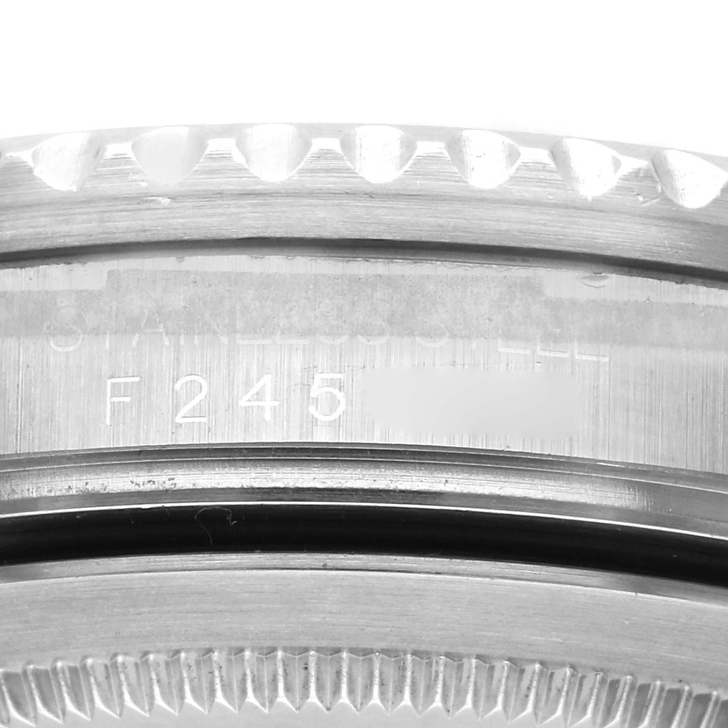 The image shows a close-up of the serial number engraving and bezel teeth of a Rolex GMT-Master 16710 Men
s Stainless Steel Black Dial 16710 Men
s Stainless Steel Black Dial watch.