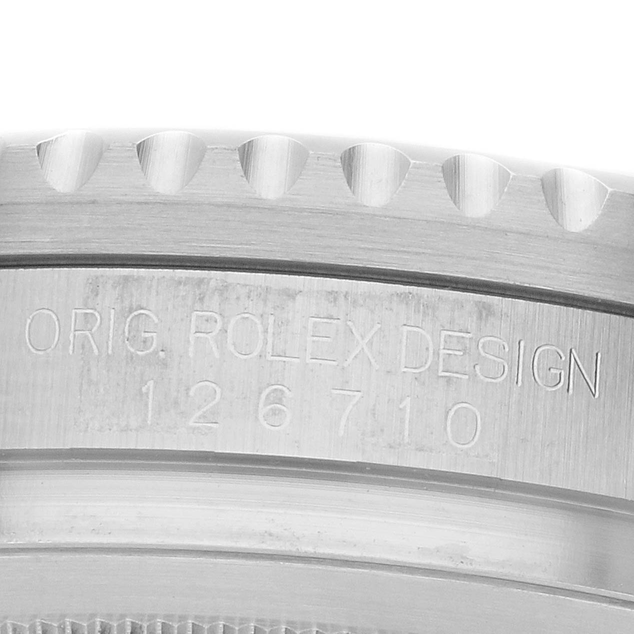 The image shows a close-up of the edge of a Rolex GMT-Master 126710 Men's Stainless Steel Black Dial model, featuring the engraved model number and design details.