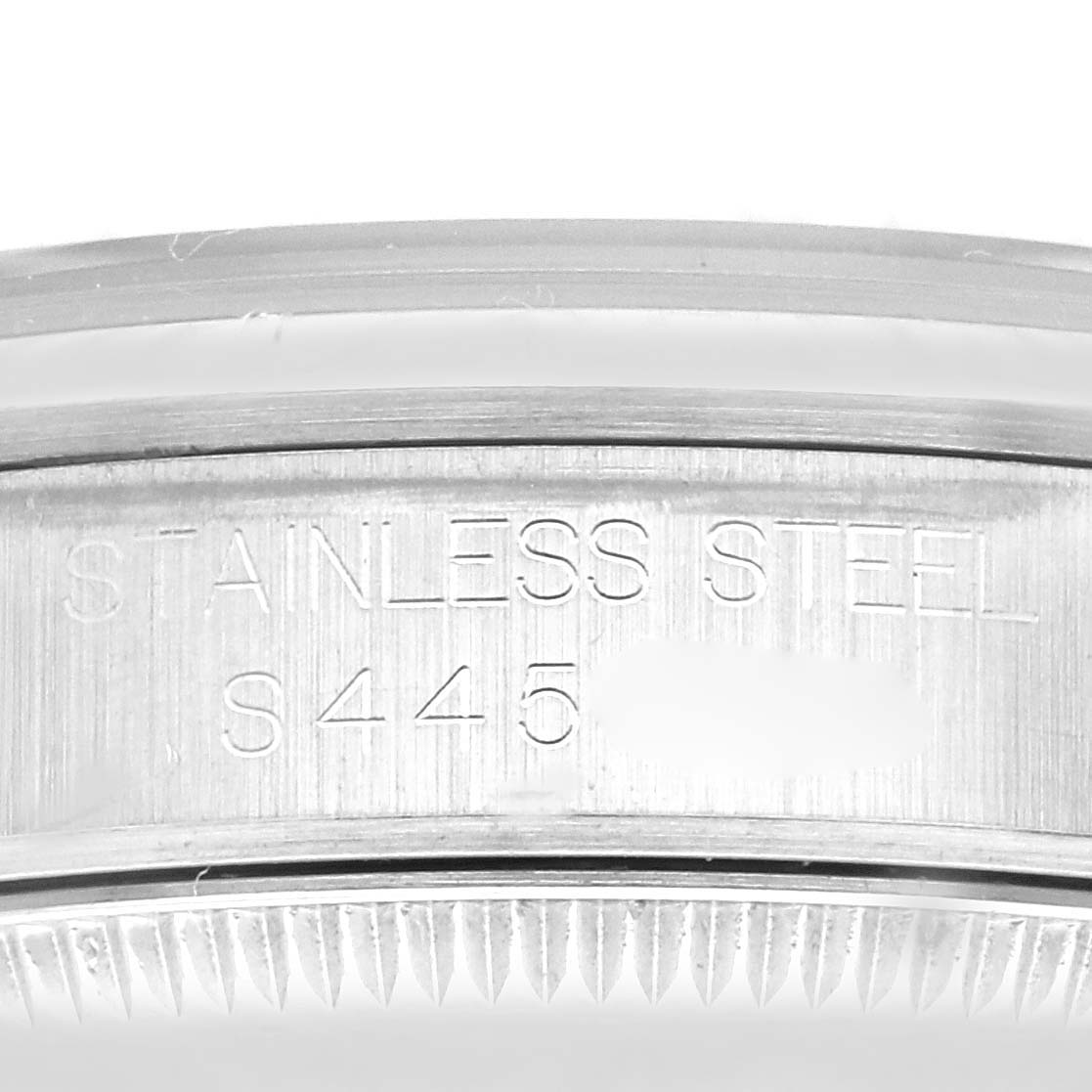 The image shows the inner side of the bezel of a Mid-Size Rolex watch, with "STAINLESS STEEL S445" engraved.