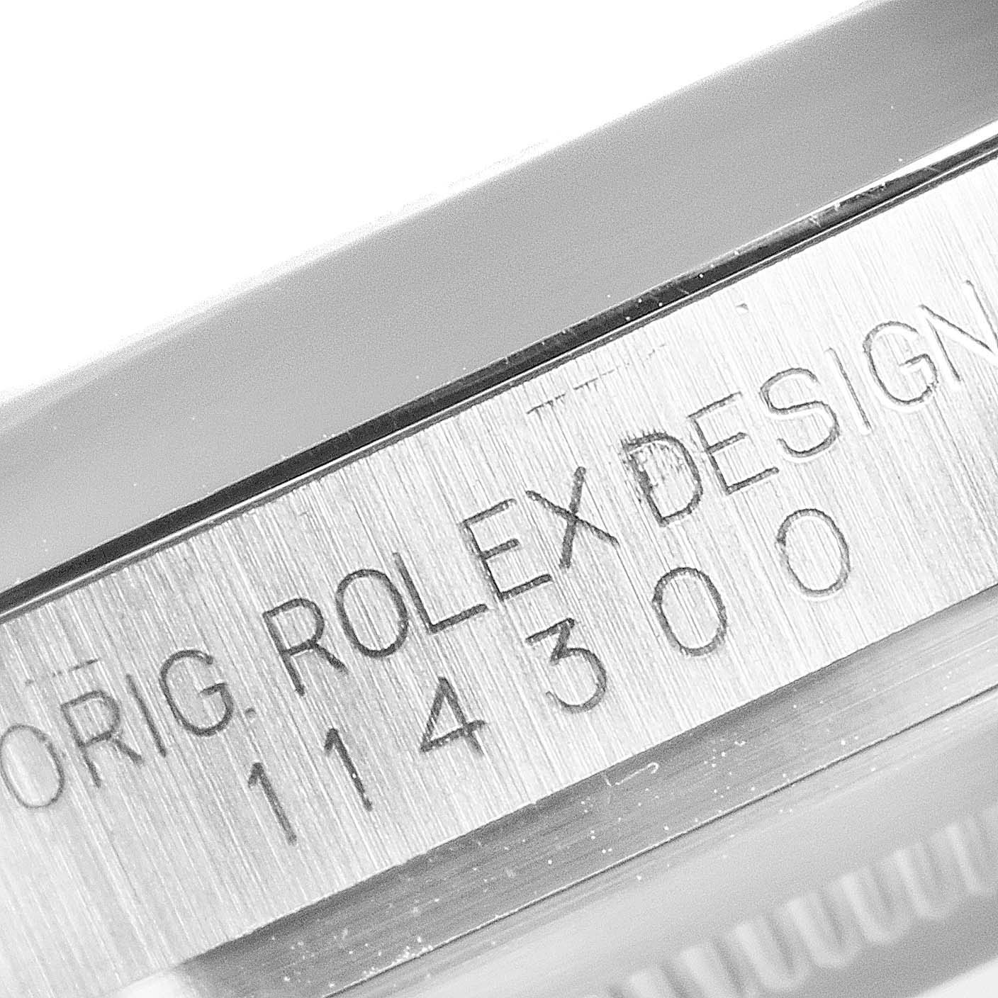 The image shows a close-up angle of the engraved model number and branding on the side of the Rolex Oyster Perpetual 114300 Men's Stainless Steel Blue Dial 114300 Men's Stainless Steel Blue Dial watch case.