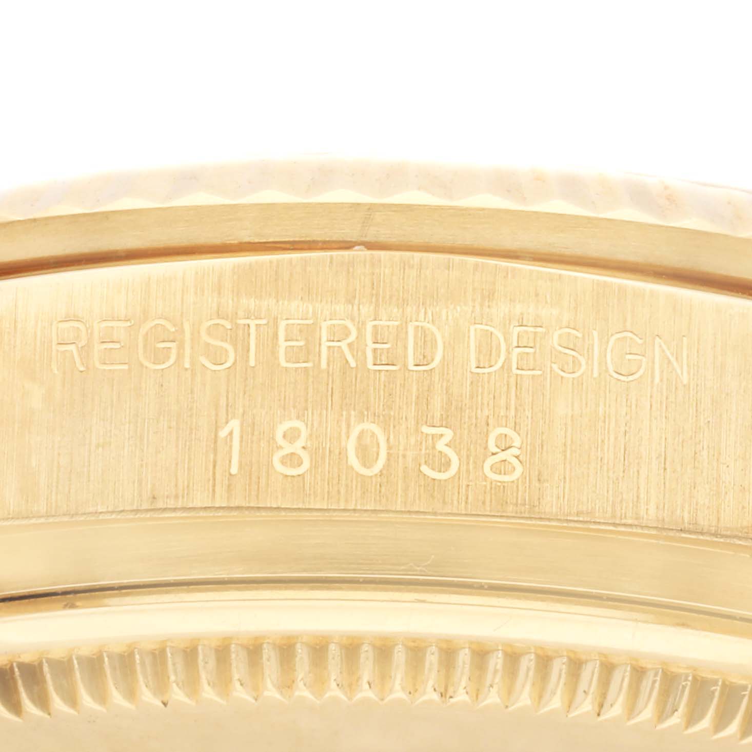 The image shows a close-up angle of the case back edge of a Rolex President 18038 Men
s Yellow Gold Champagne Dial 18038 Men
s Yellow Gold Champagne Dial model, displaying "REGISTERED DESIGN 18038".