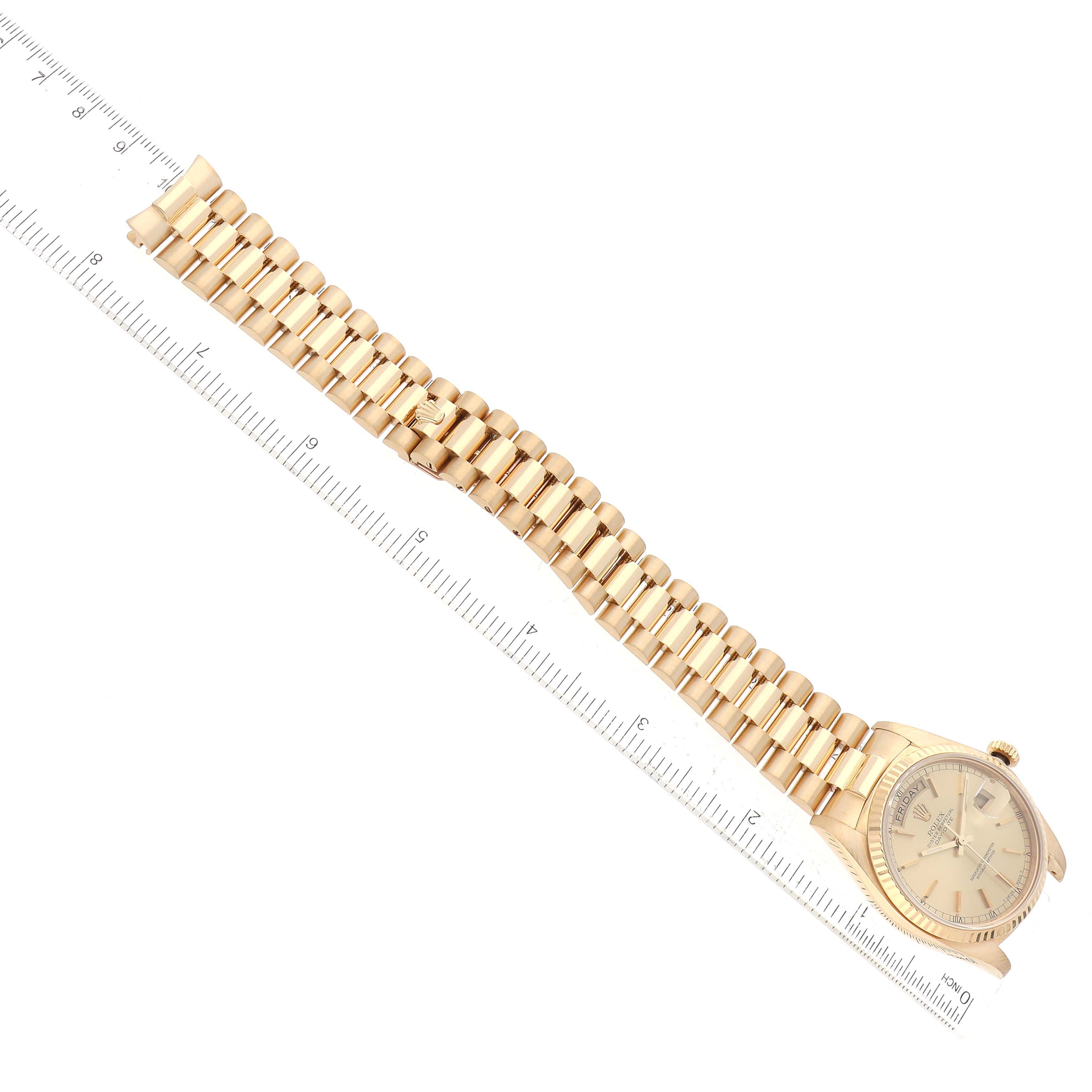 The image shows a Rolex President 18038 Men
s Yellow Gold Champagne Dial 18038 Men
s Yellow Gold Champagne Dial model watch flat with a full view of the bracelet and face positioned against a ruler.