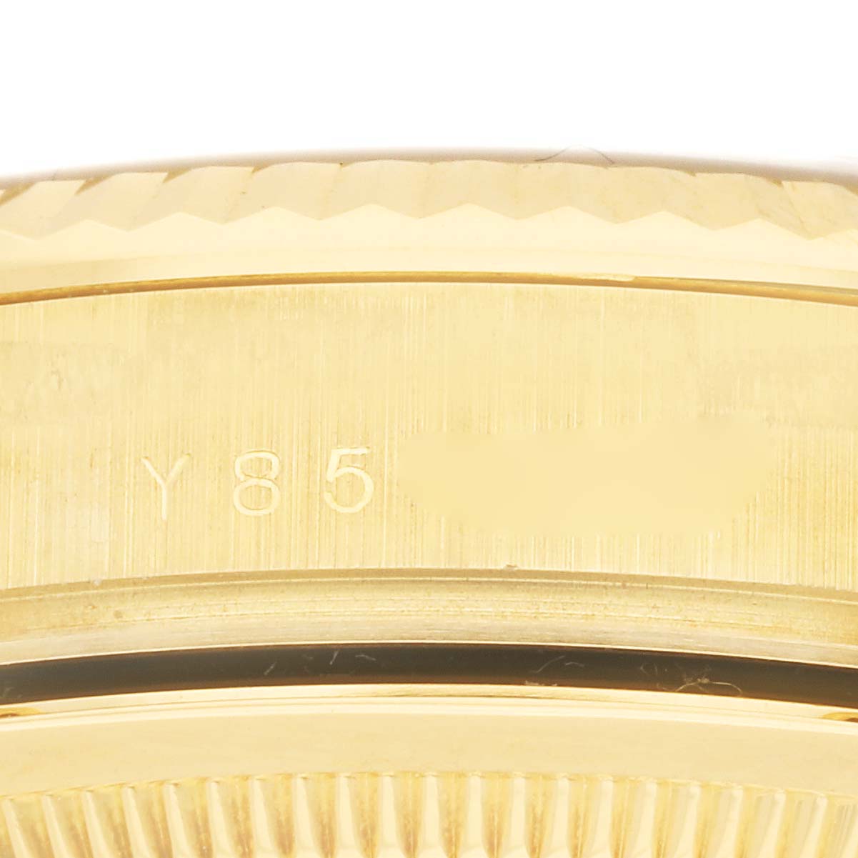 This is a close-up shot of the Rolex President 118238 Men
s Yellow Gold Champagne Dial 118238 Men
s Yellow Gold Champagne Dial model watch showing part of its bezel and the serial number.