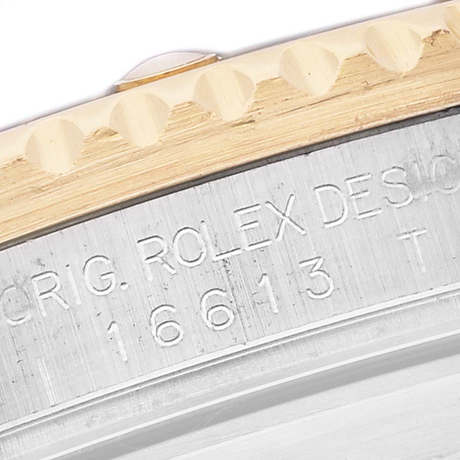 This image is a close-up of the side engraving on the bezel and case of a Rolex Submariner 16613 Men's Steel and Gold (two tone) Blue Dial 16613 Men's Steel and Gold (two tone) Blue Dial watch.