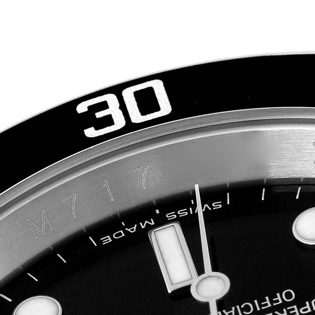 This close-up image of a Rolex Submariner 16610 Men
s Stainless Steel Black Dial 16610 Men
s Stainless Steel Black Dial watch shows the bezel with the number 30, part of the dial, minute hand, and part of the hour marker.