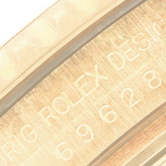 Close-up shot of the side engraving on a Rolex Yacht-Master 69628 Women's Yellow Gold Blue Dial 69628 Women's Yellow Gold Blue Dial, displaying the model number and "ROLEX DESIGN" text.