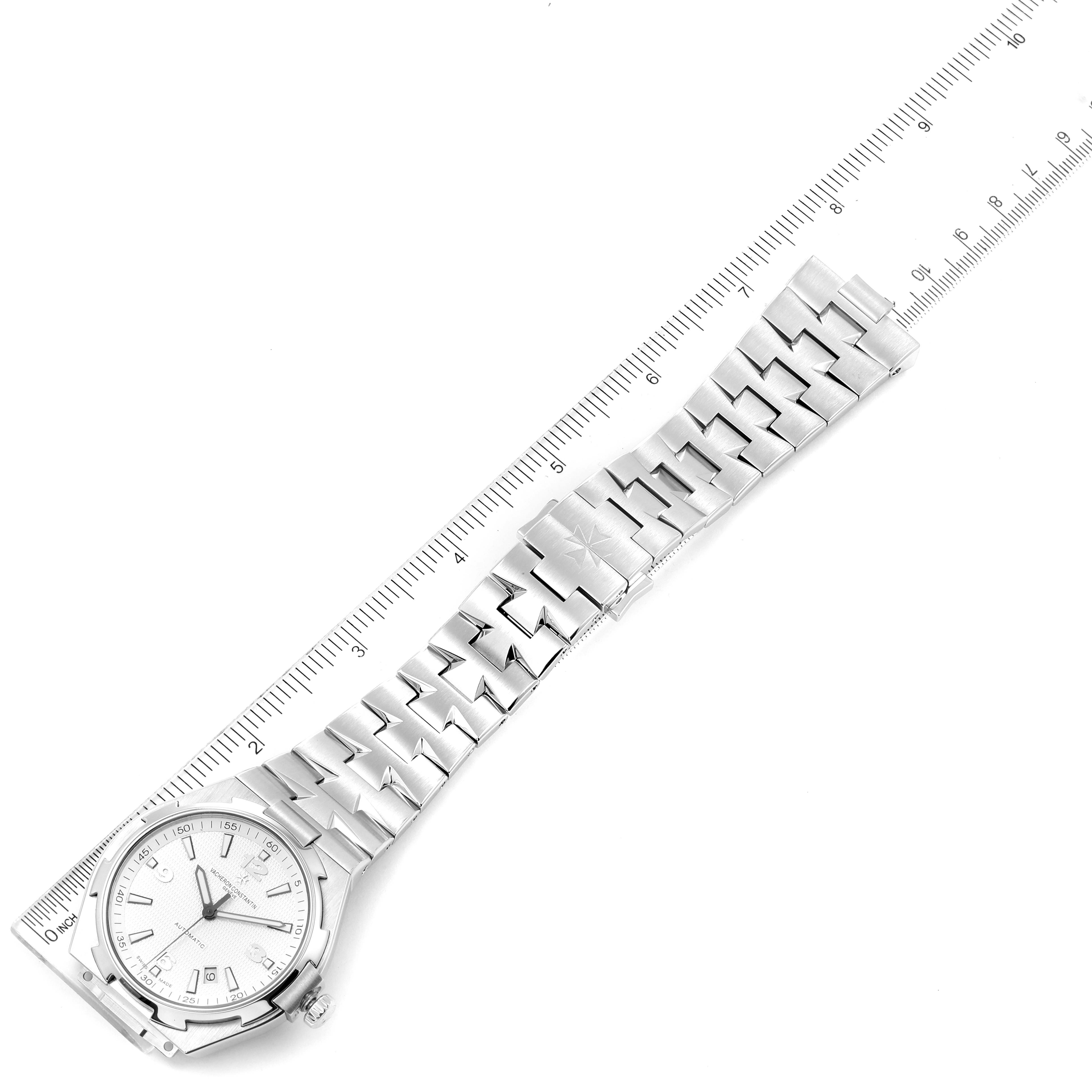 The image shows a Vacheron Constantin Overseas 47040B01A-9093 Men's Stainless Steel Silver Dial 47040B01A-9093 Men's Stainless Steel Silver Dial watch aligned with a ruler, highlighting the bracelet and dial face.