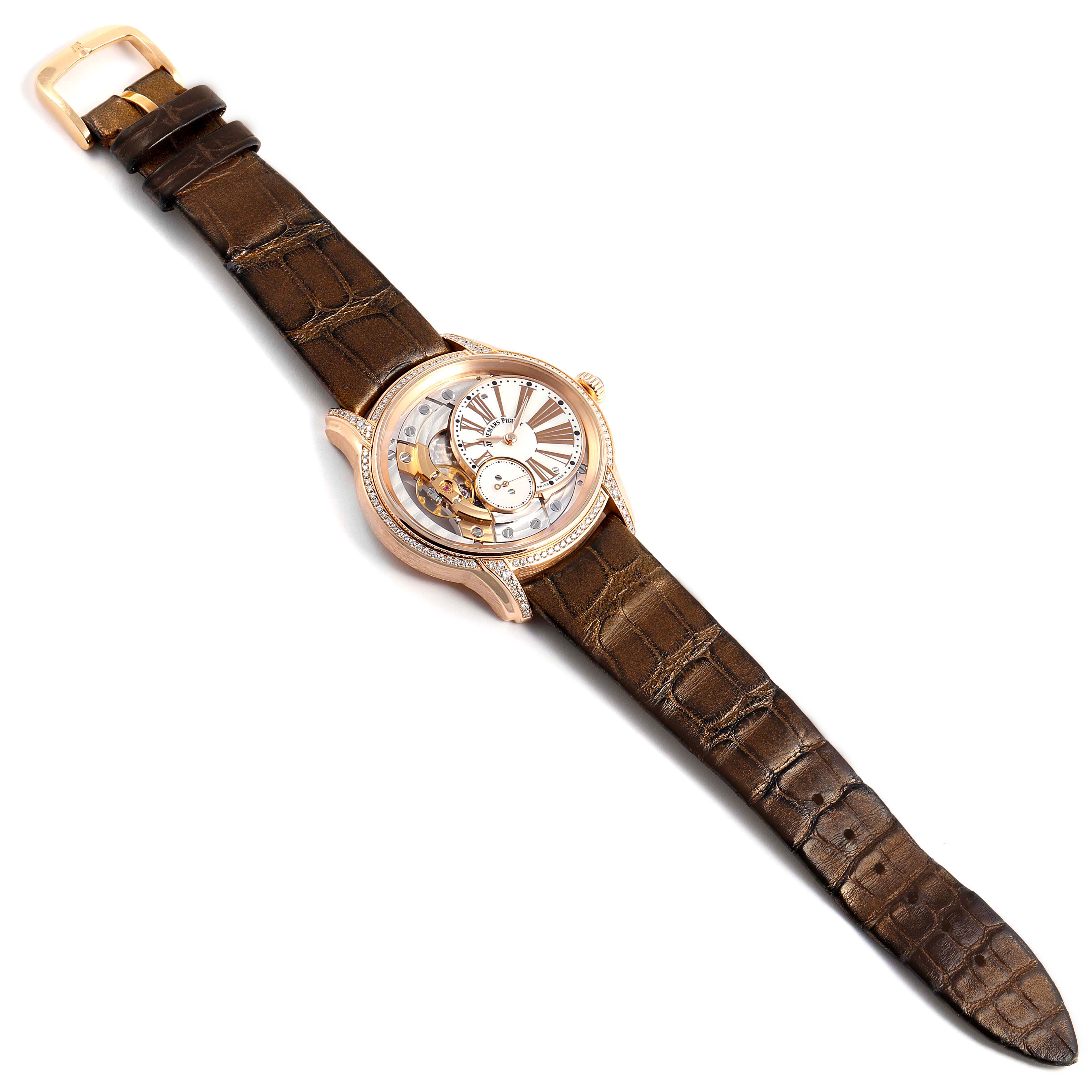 The image shows an Audemars Piguet Millenary 77247OR.ZZ.1272OR.01 Women's Rose Gold Mother of Pearl Dial 77247OR.ZZ.1272OR.01 Women's Rose Gold Mother of Pearl Dial watch at a top-down angle, featuring its dial, case, and leather strap. 