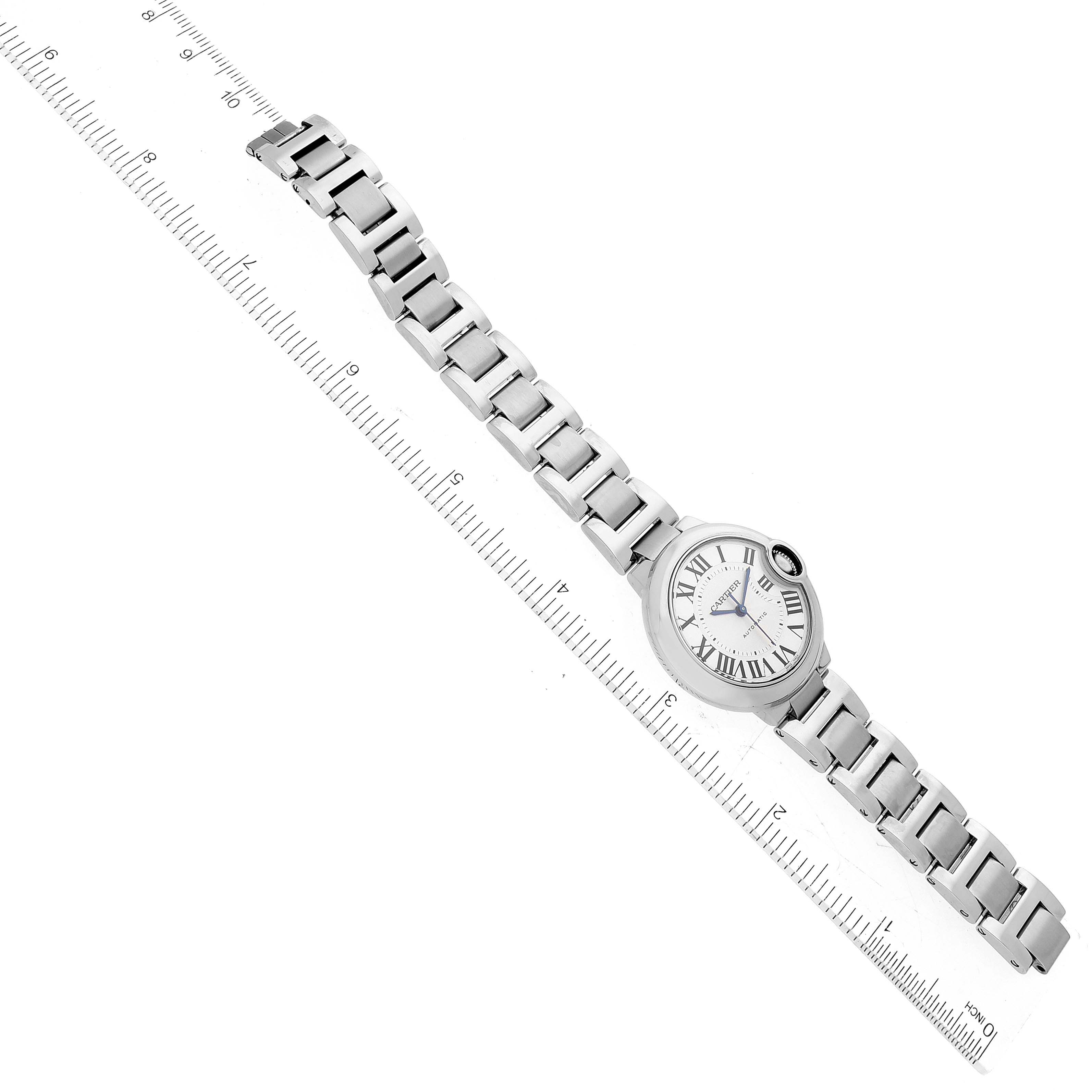 The image shows a top-down view of a Cartier Ballon Bleu W6920071 Women
s Stainless Steel Silver Dial W6920071 Women
s Stainless Steel Silver Dial watch, including the dial, bracelet, and a ruler for size reference.