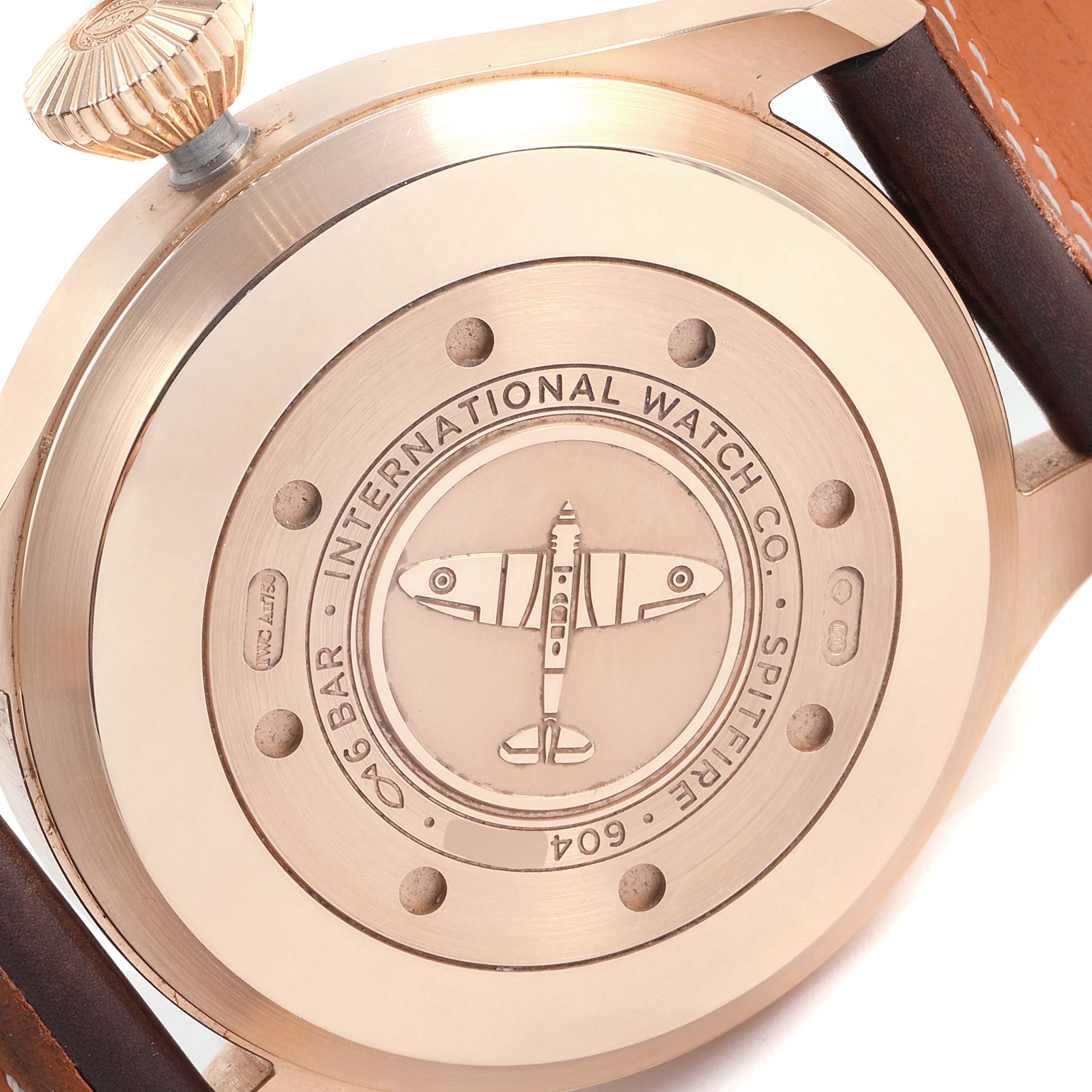 This image shows the engraved case back of the IWC Pilot IW500917 Men's Rose Gold Grey Dial IW500917 Men's Rose Gold Grey Dial's Watch, depicting a plane and branding details.