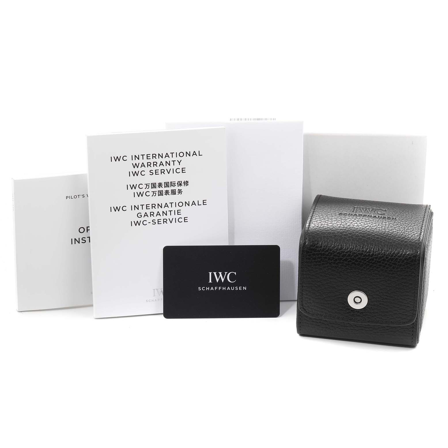 The image shows the accessories for the IWC Pilot IW389103 Men's Titanium Brown Dial IW389103 Men's Titanium Brown Dial watch, including manuals, a warranty card, and a leather watch case.