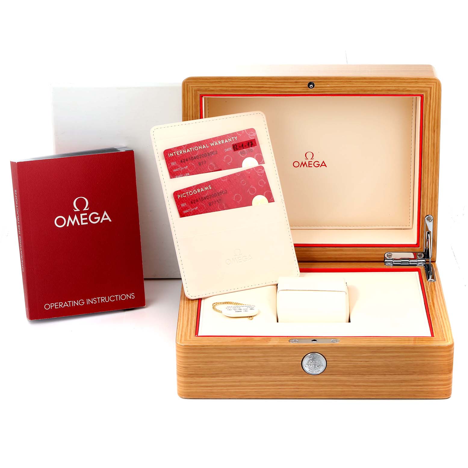 The De Ville model by Omega is displayed in its open wooden box, alongside warranty cards, instructions, and a cardholder.