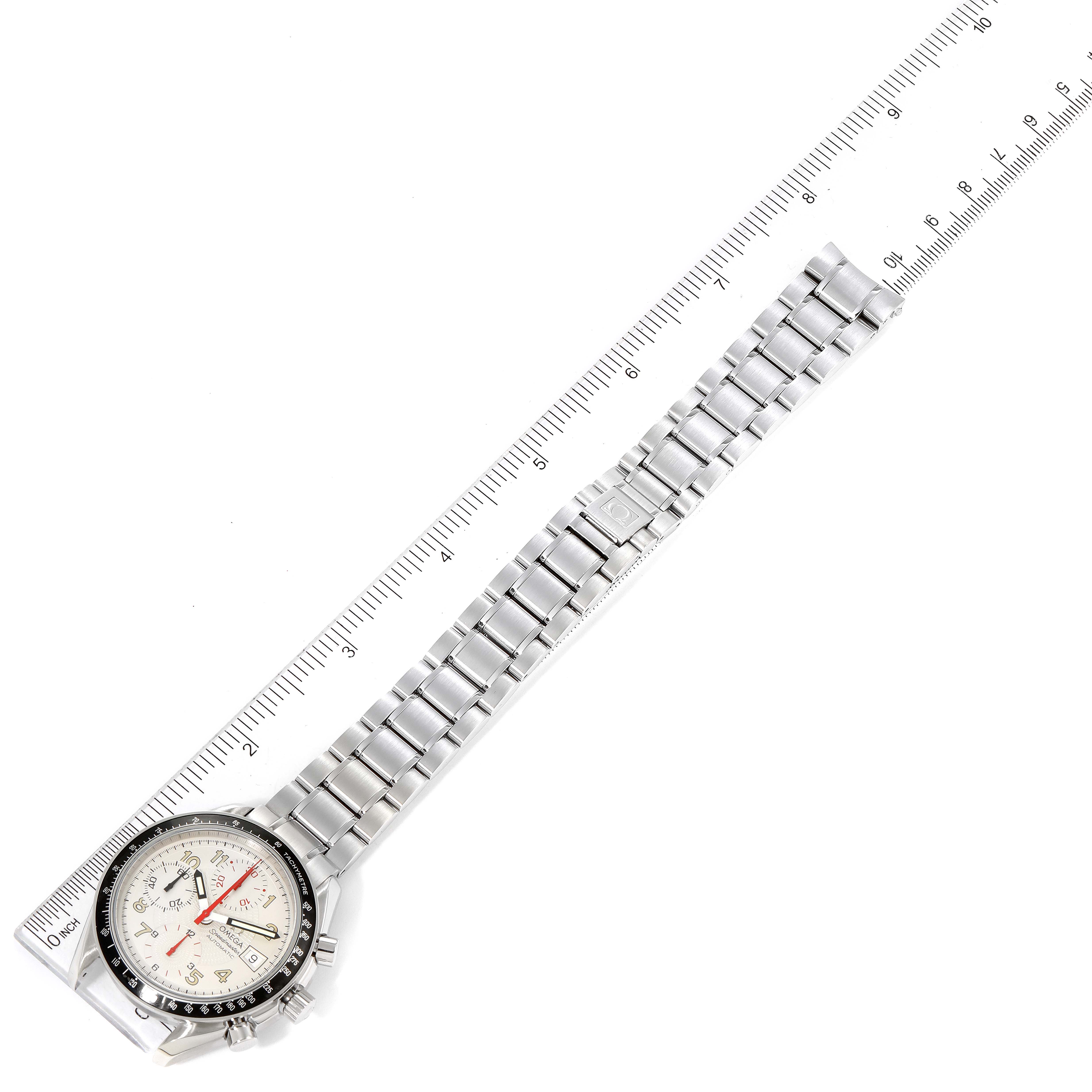 The image shows an Omega Speedmaster 3513.33.00 Men
s Stainless Steel White Dial 3513.33.00 Men
s Stainless Steel White Dial watch laid flat alongside a ruler, highlighting its stainless steel bracelet and dial.