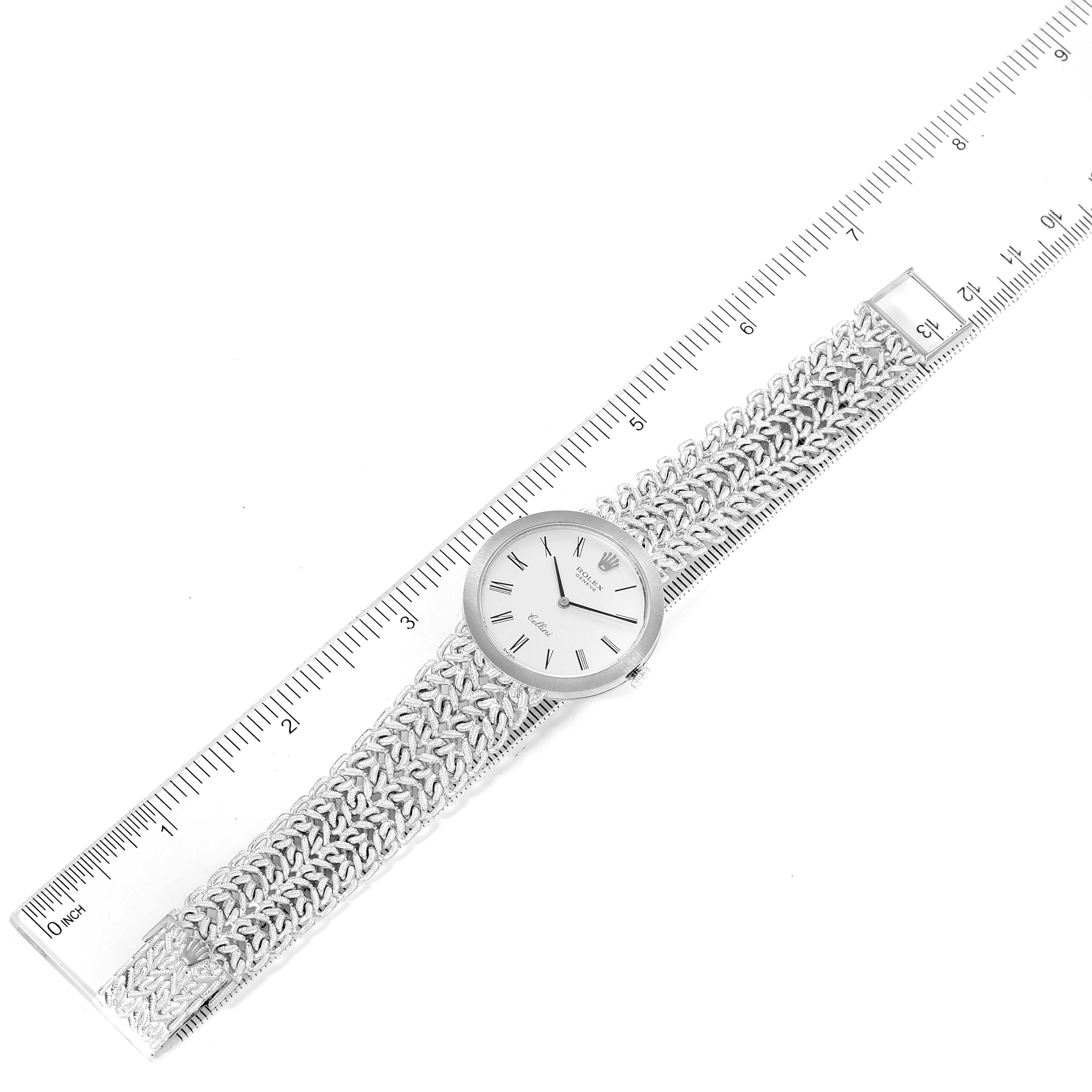 The image shows a Rolex Cellini 3838 Women's White Gold Silver Dial 3838 Women's White Gold Silver Dial watch laid flat next to a ruler, displaying its face, case, and textured band.
