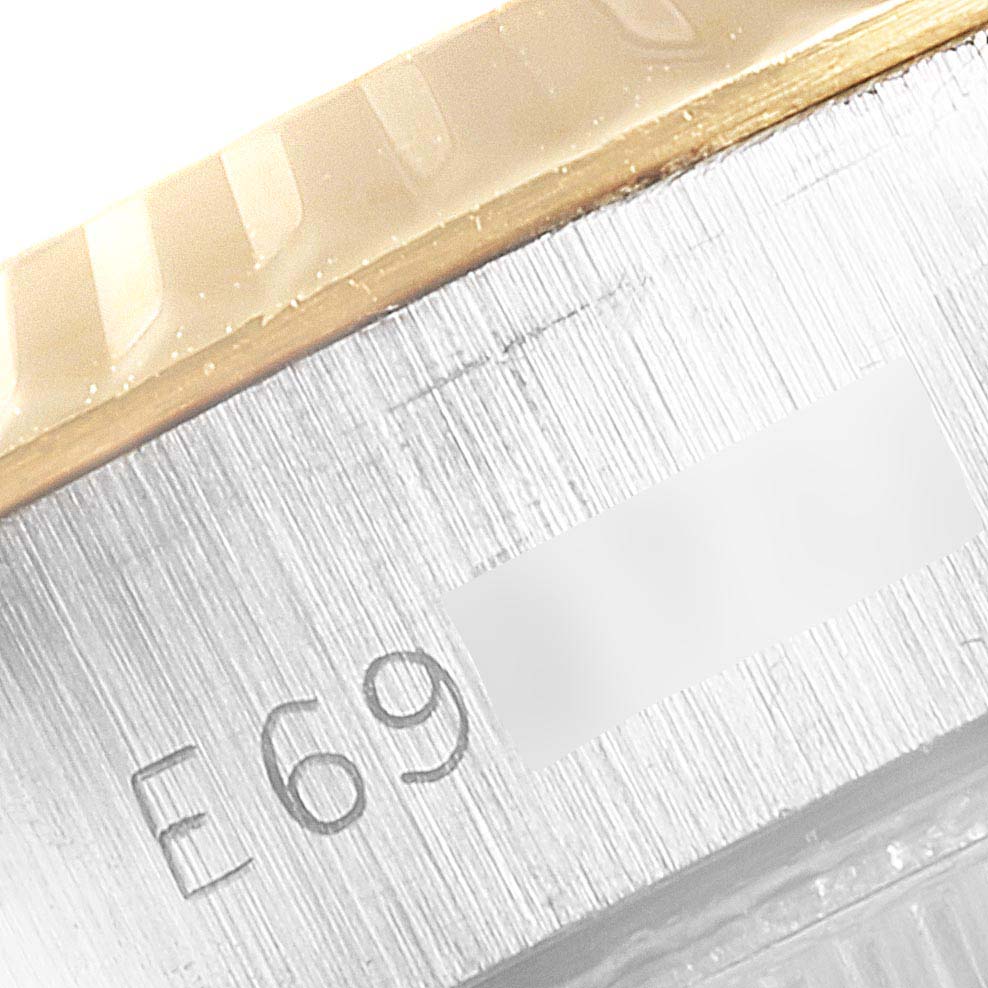 The image shows a close-up of the Rolex Datejust 69173 Women's Stainless Steel Champagne Dial 69173 Women's Stainless Steel Champagne Dial watch bezel and part of the case, including serial number engravings.