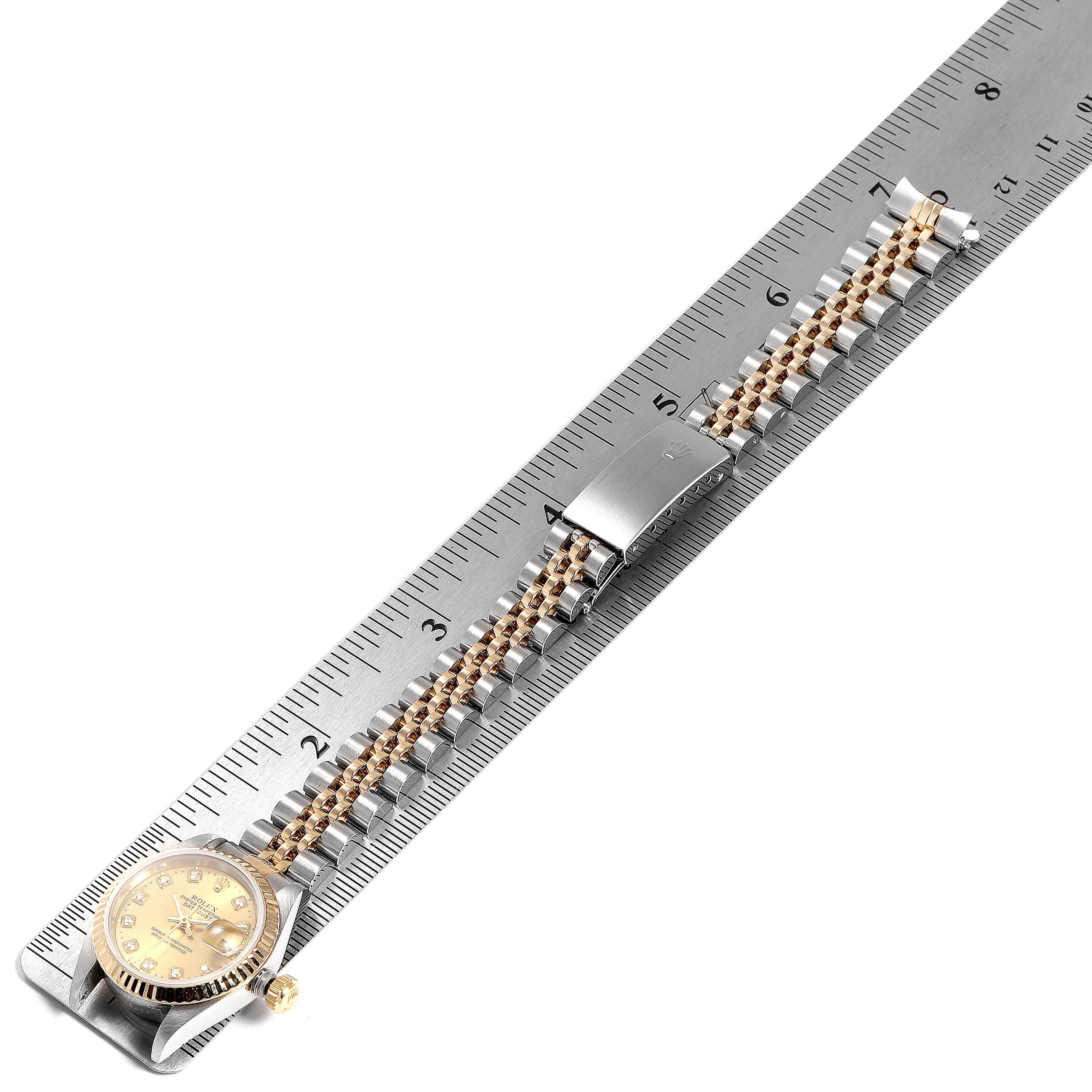The image shows a Rolex Datejust 69173 Women's Stainless Steel Champagne Dial 69173 Women's Stainless Steel Champagne Dial watch laid flat next to a ruler, highlighting its bracelet, clasp, and dial.