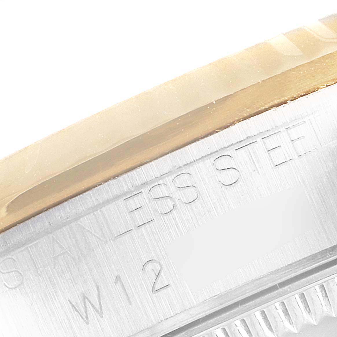This image shows a close-up of the engraved side of a stainless steel Mid-Size Rolex watch case, with part of the bezel visible.