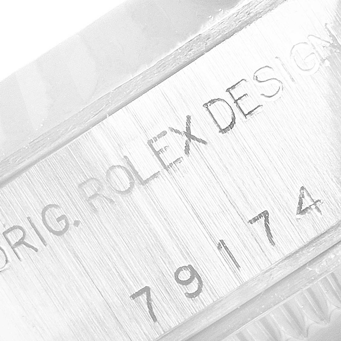 The image shows a close-up of the serial number engraving on the case of a Rolex Datejust 79174 Women's Stainless Steel Silver Dial 79174 Women's Stainless Steel Silver Dial watch.