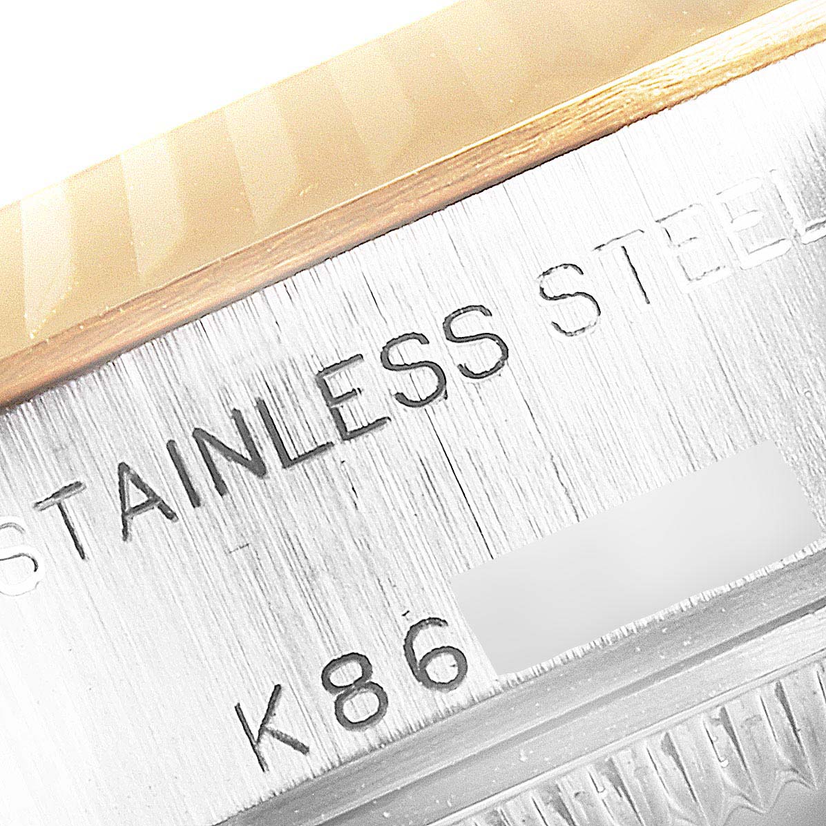 The image shows a close-up of the case side engraving of a Rolex Datejust 79173 Women's Stainless Steel Champagne Dial 79173 Women's Stainless Steel Champagne Dial watch, featuring "STAINLESS STEEL" text and a serial number.