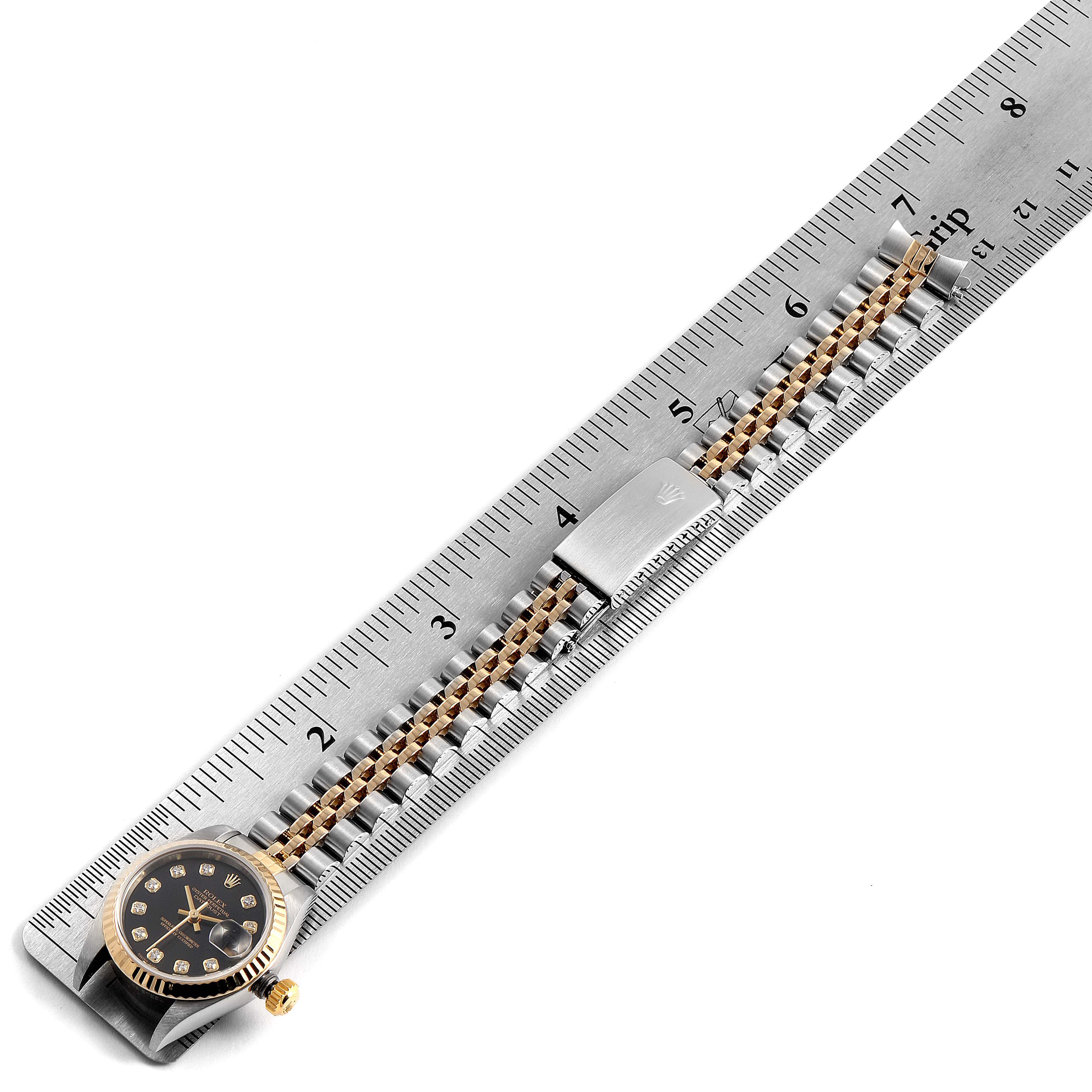 The image shows a Rolex Datejust 79173 Women's Stainless Steel Black Dial 79173 Women's Stainless Steel Black Dial watch, face-up, alongside a metal ruler measuring its bracelet length.